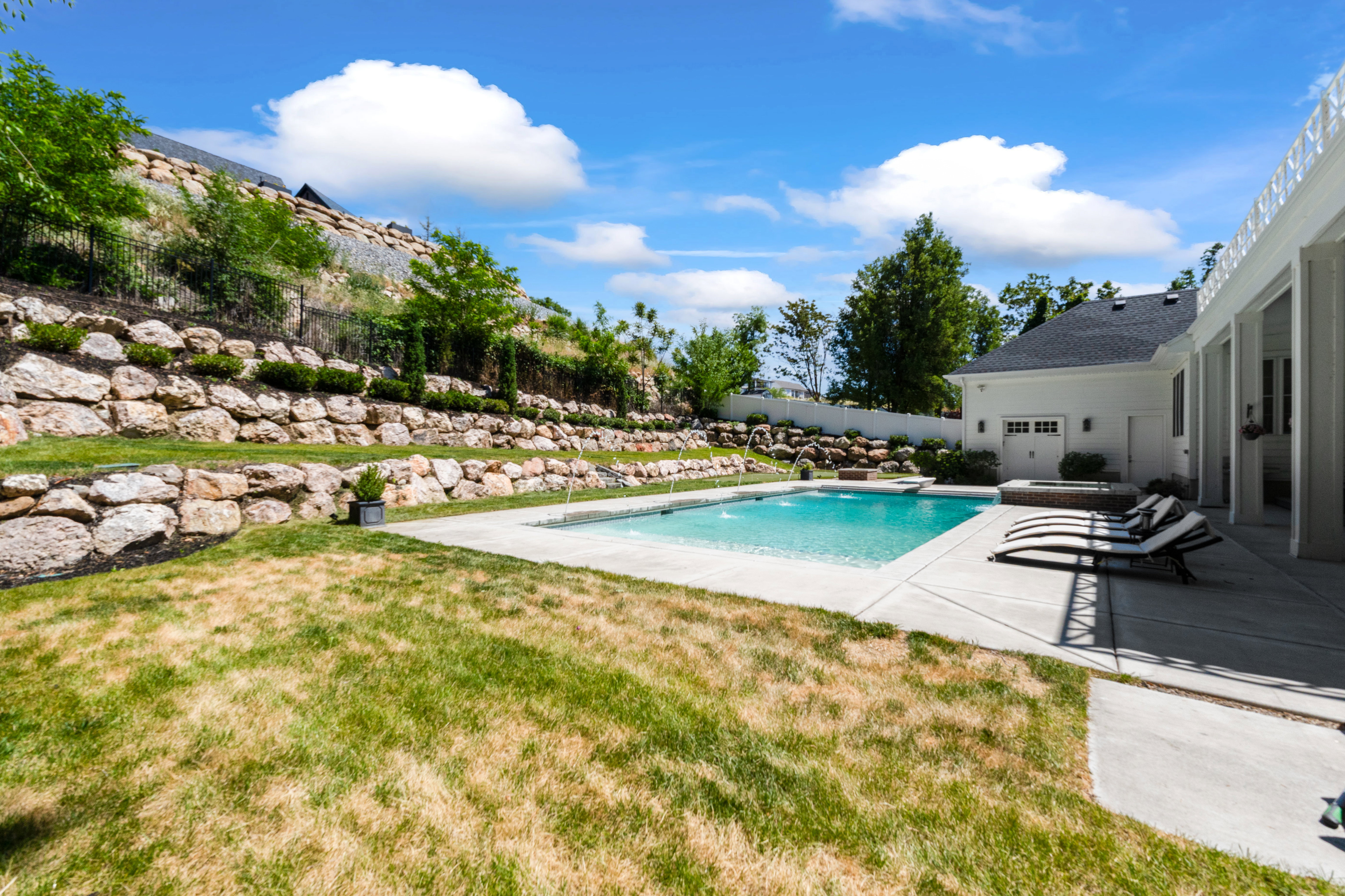 Outdoor swimming pool with integrated spa and concrete surround