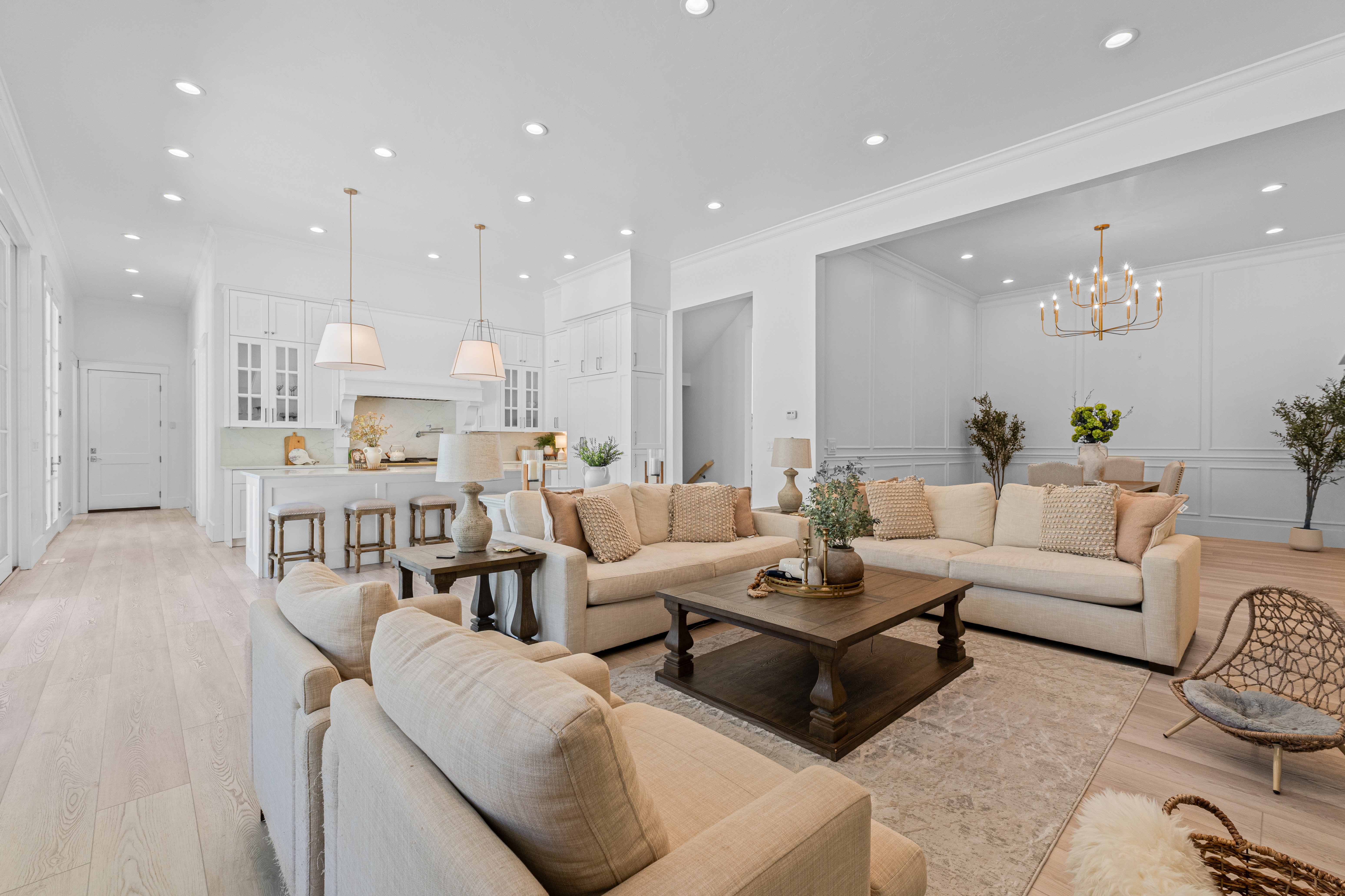 Open-concept living space featuring wood-finish flooring, recessed lighting, and crown molding