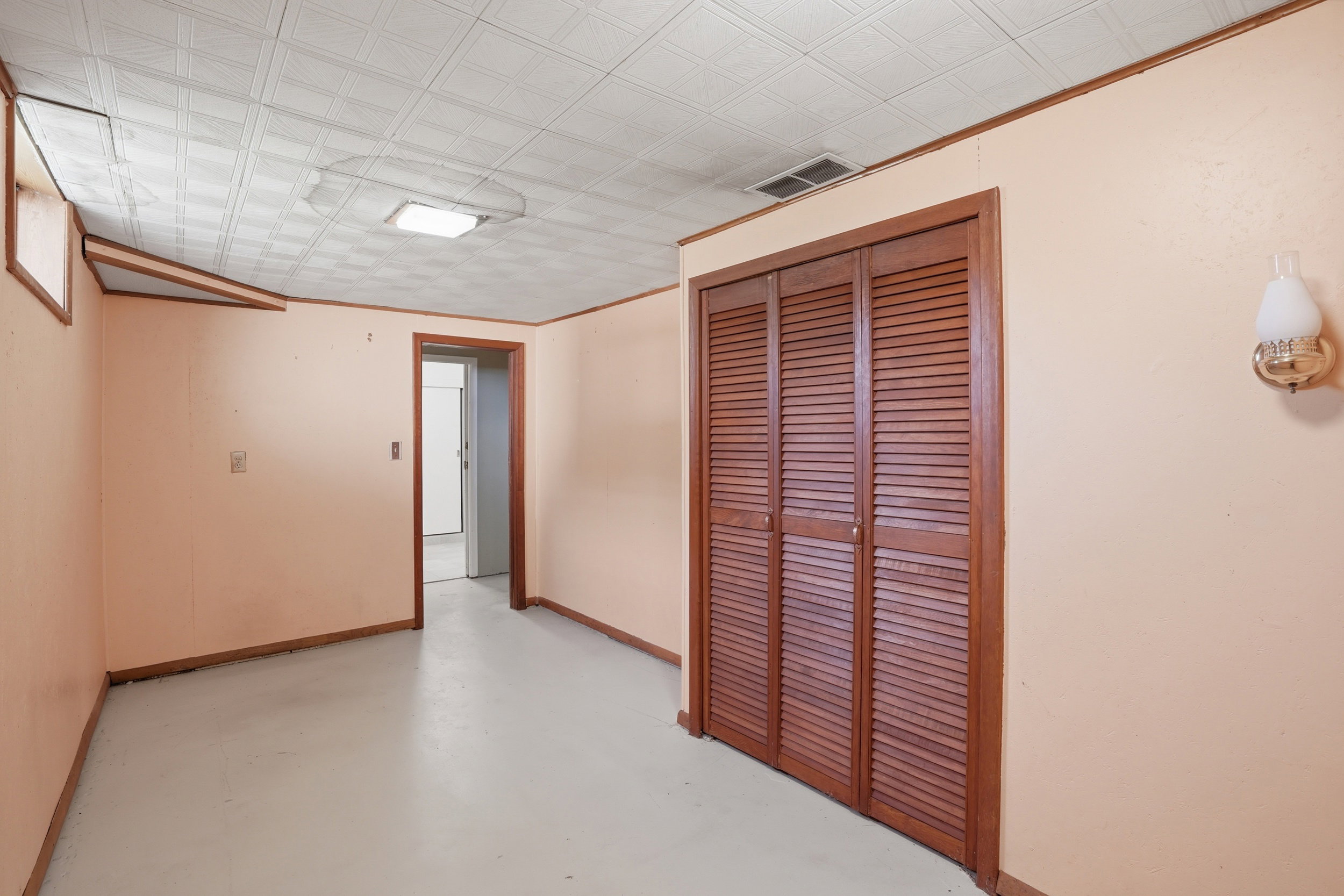 Room featuring a square ceiling light and white acoustic ceiling tiles