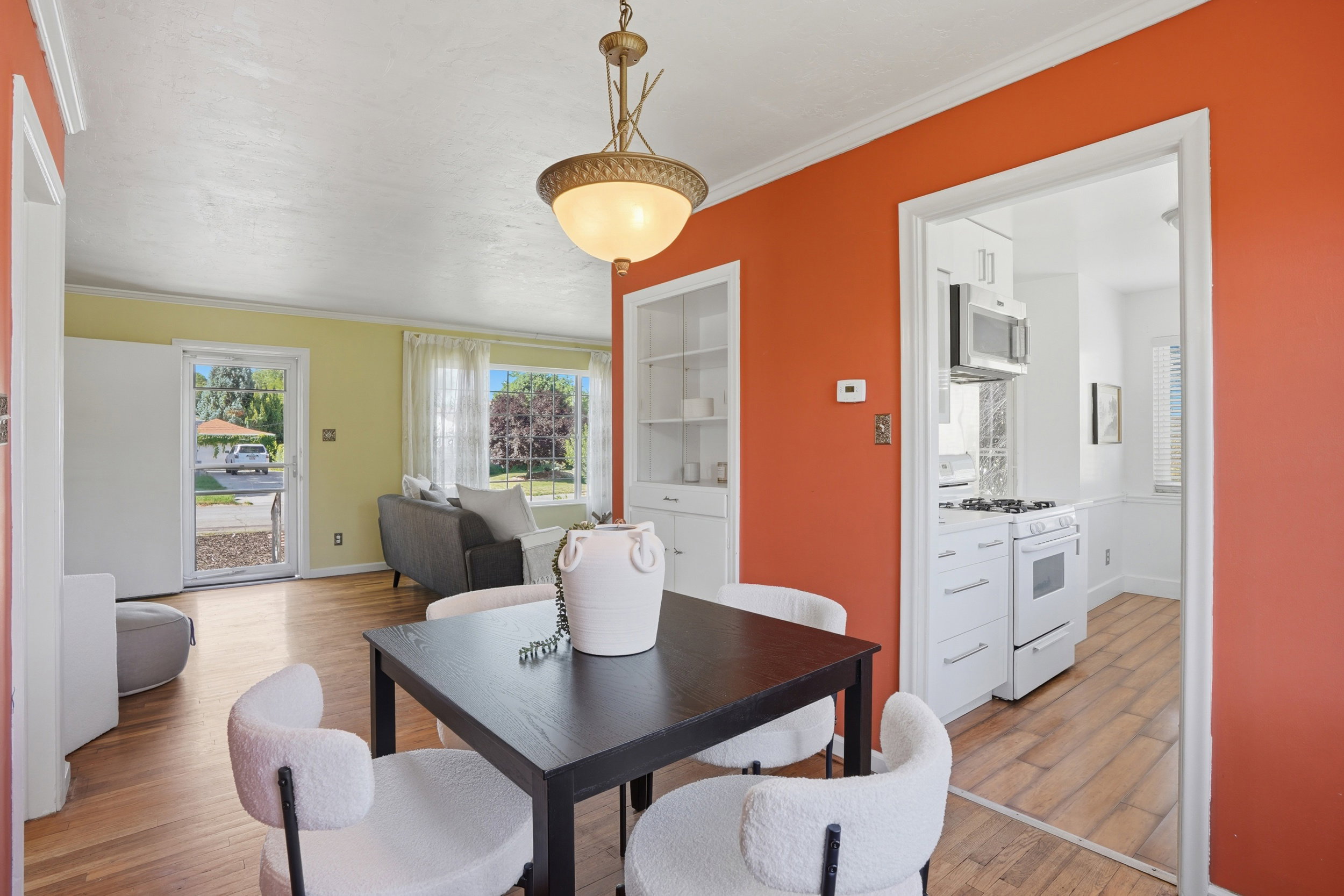 Dining area featuring wood-finish flooring, a decorative overhead light fixture, and a built-in display cabinet