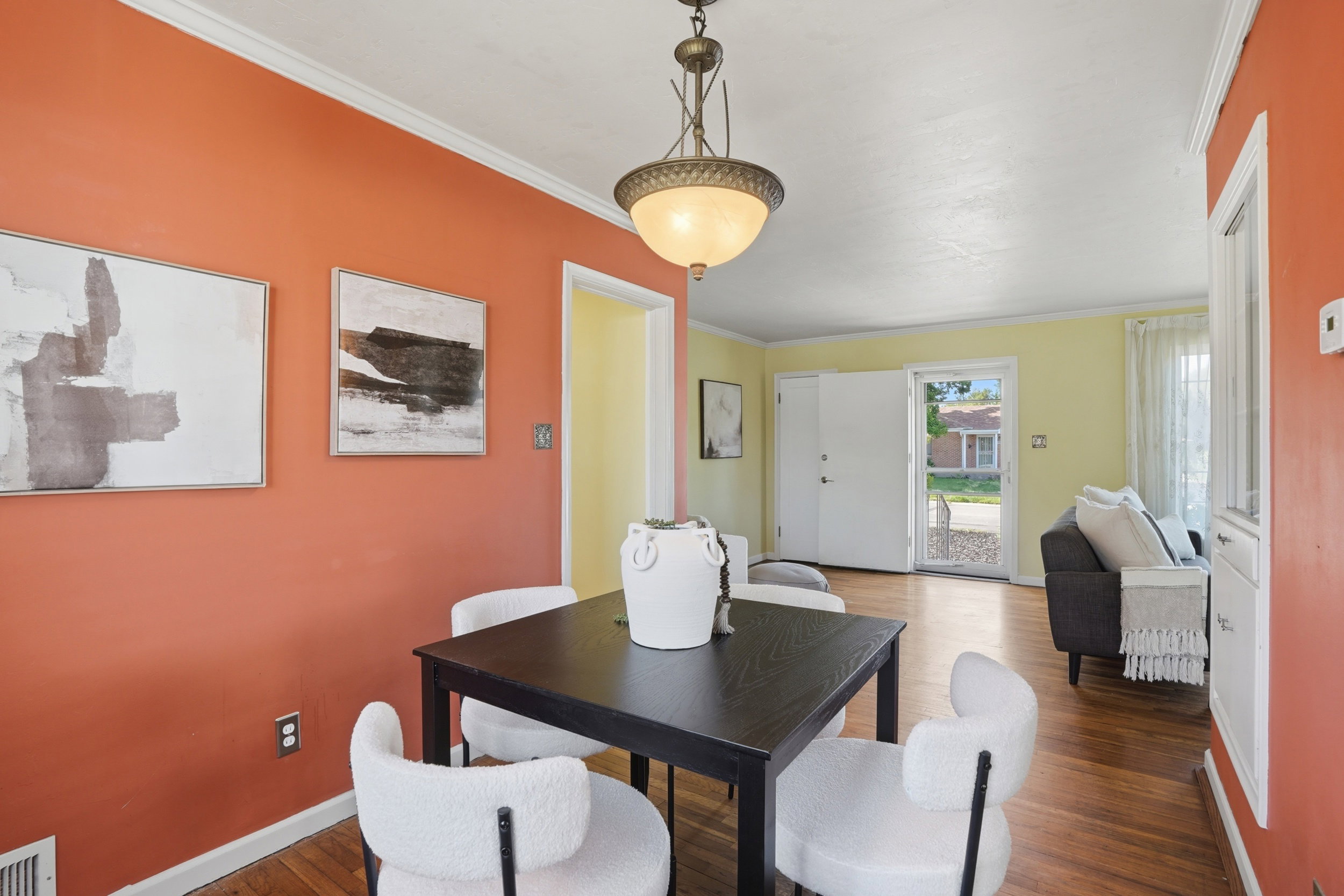 Dining area featuring wood-finish flooring, a contemporary chandelier, and crown molding