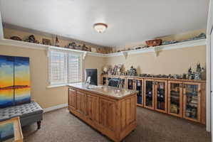 Room featuring extensive built-in cabinetry with glass-front doors, open shelving, and a window with plantation shutters