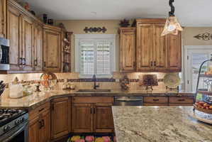 Kitchen featuring wood cabinetry, granite countertops, and a mosaic tile backsplash