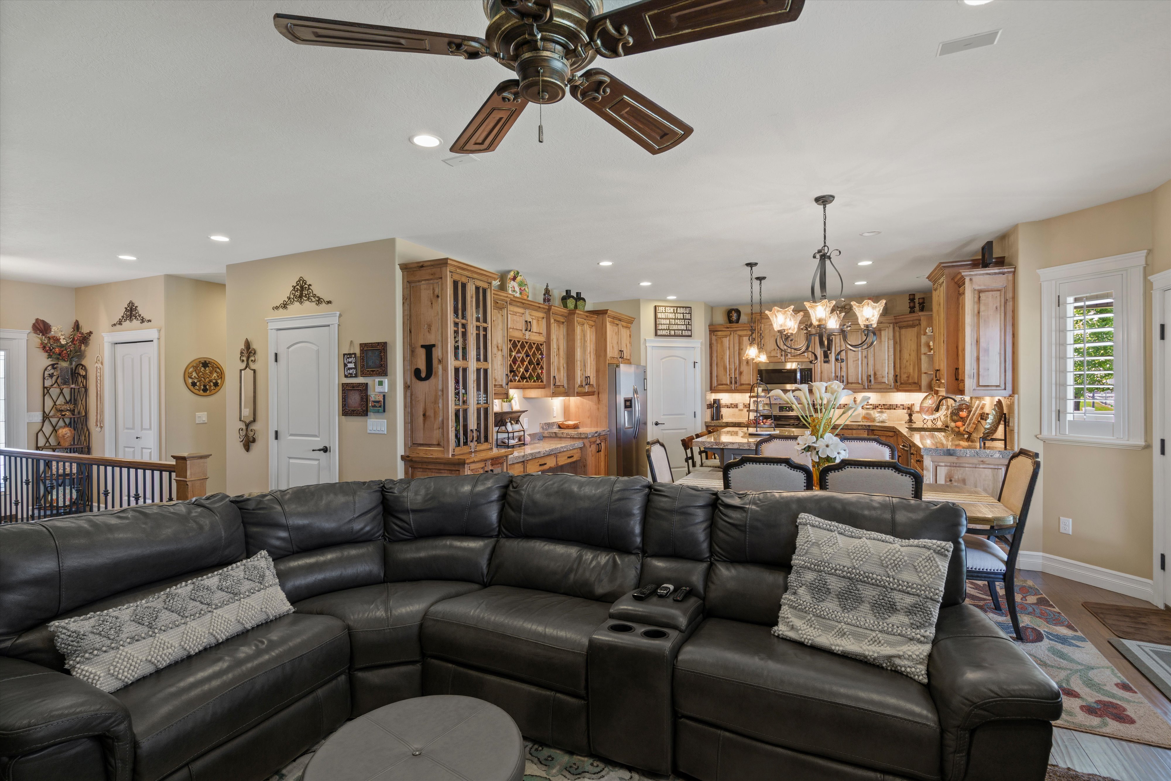 Expansive open-concept living area featuring a decorative ceiling fan, recessed lighting, and light-toned walls