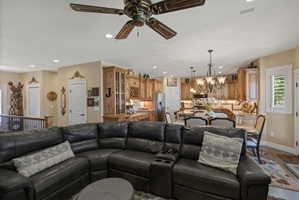 Expansive open-concept living area featuring a decorative ceiling fan, recessed lighting, and light-toned walls