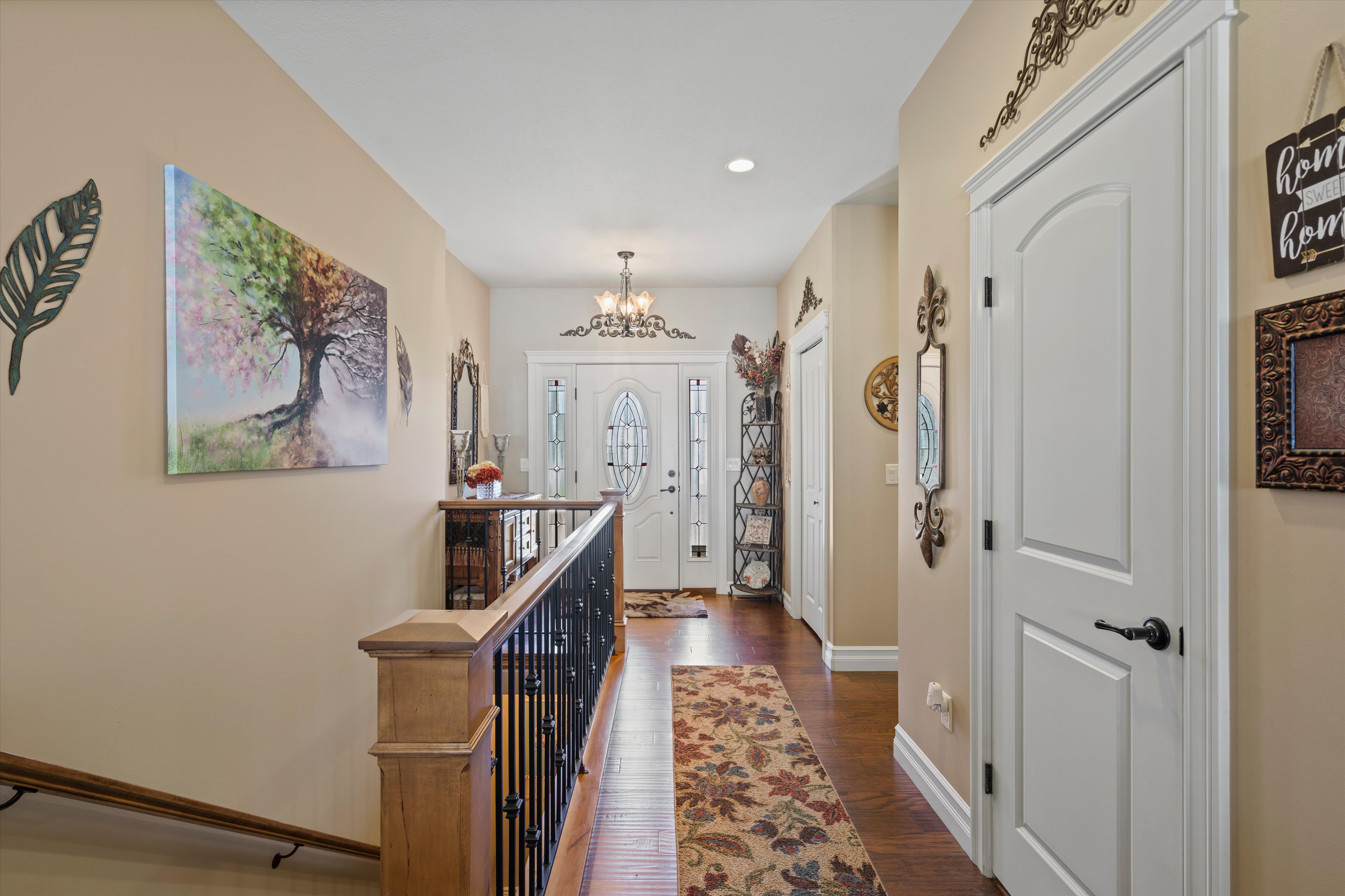 Inviting entryway featuring a white paneled front door with decorative glass, flanked by coordinating sidelights and a transom window