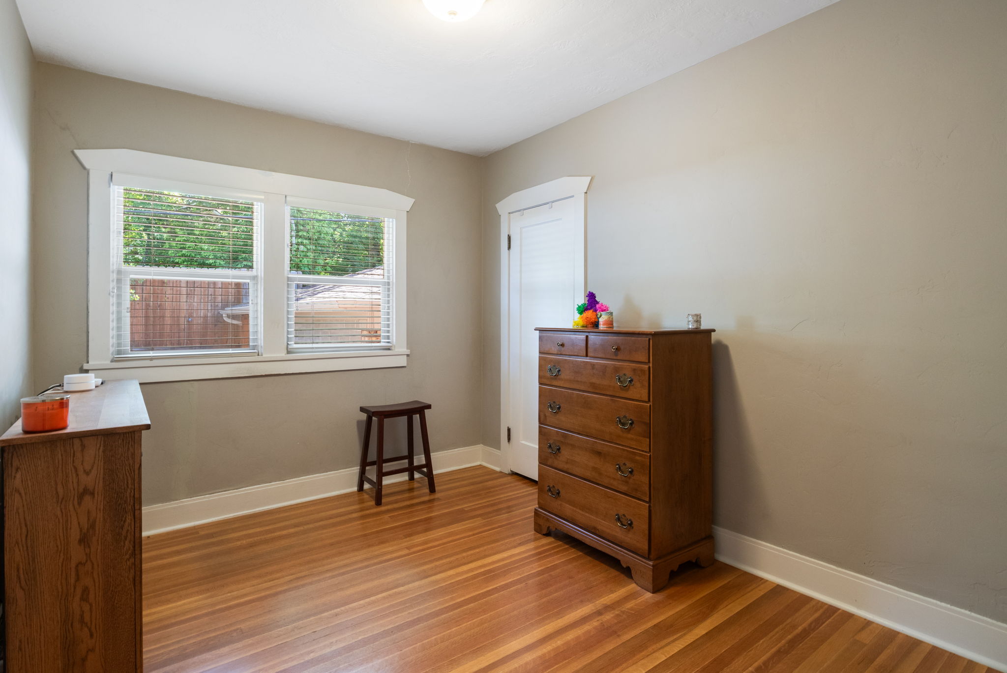 Bright room featuring wood-finish flooring and a double window with white trim