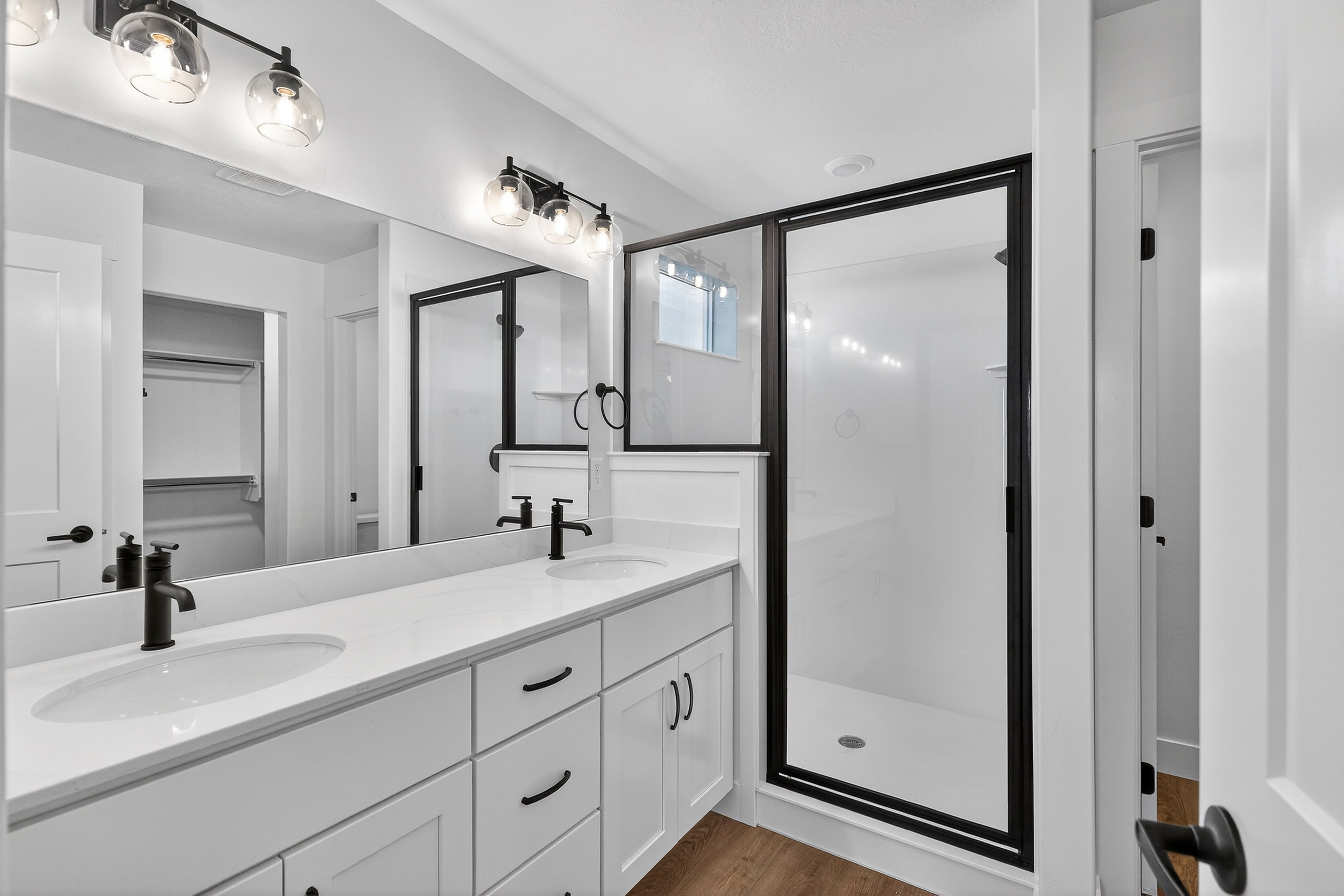 Contemporary bathroom featuring a dual vanity with white cabinetry and quartz countertops