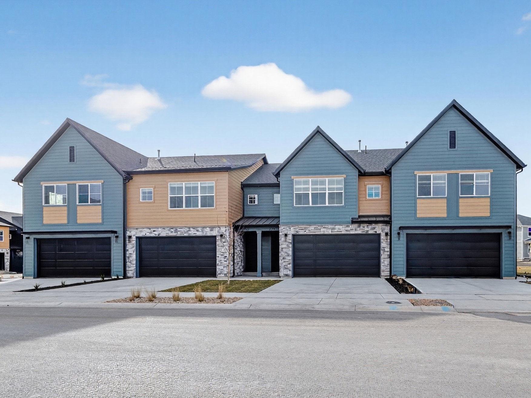 Contemporary townhome exteriors featuring blue siding, light-colored accents, and stone-finish lower facade