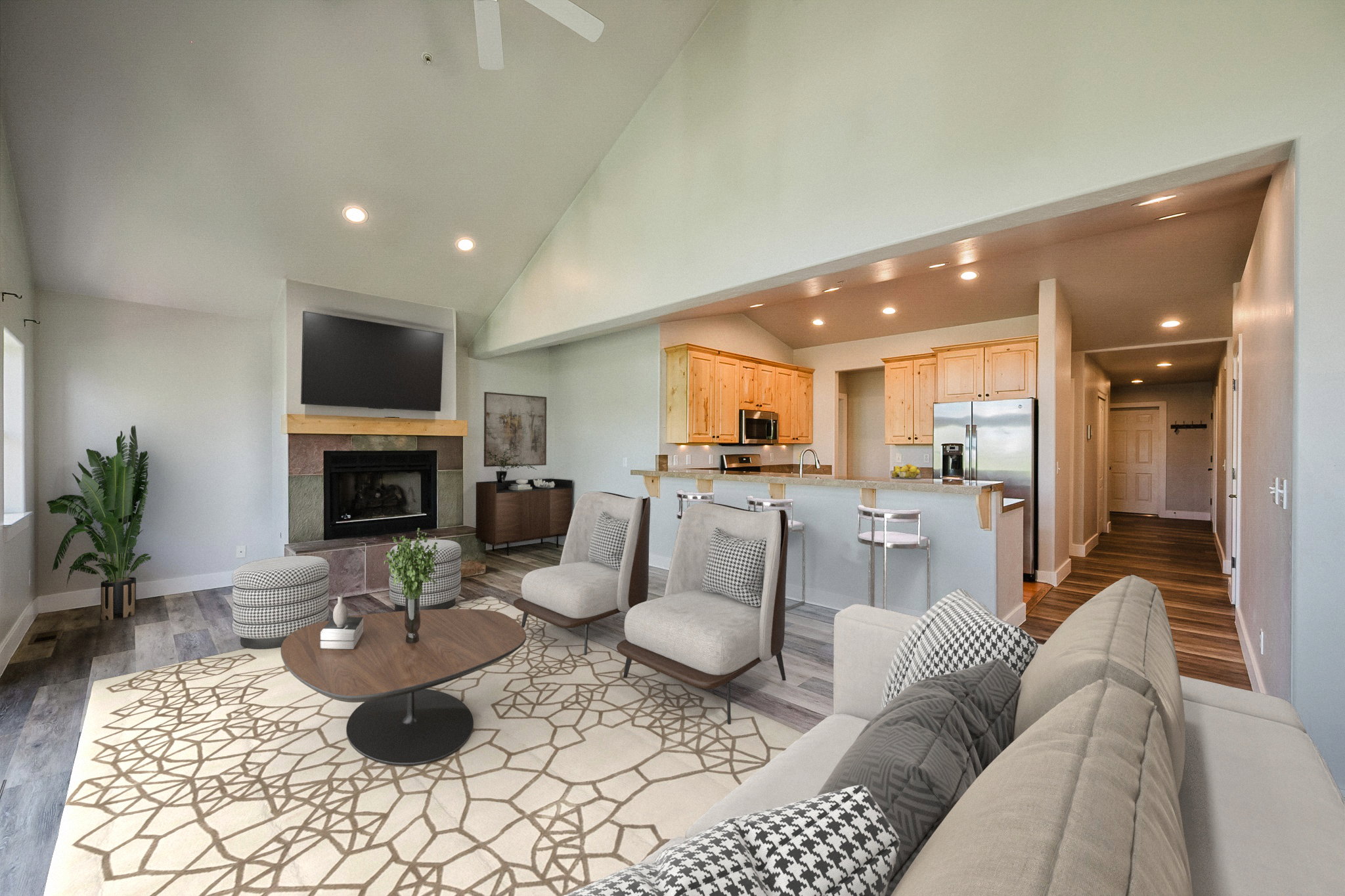 Vaulted ceiling great room with wood-finish flooring - Virtually staged