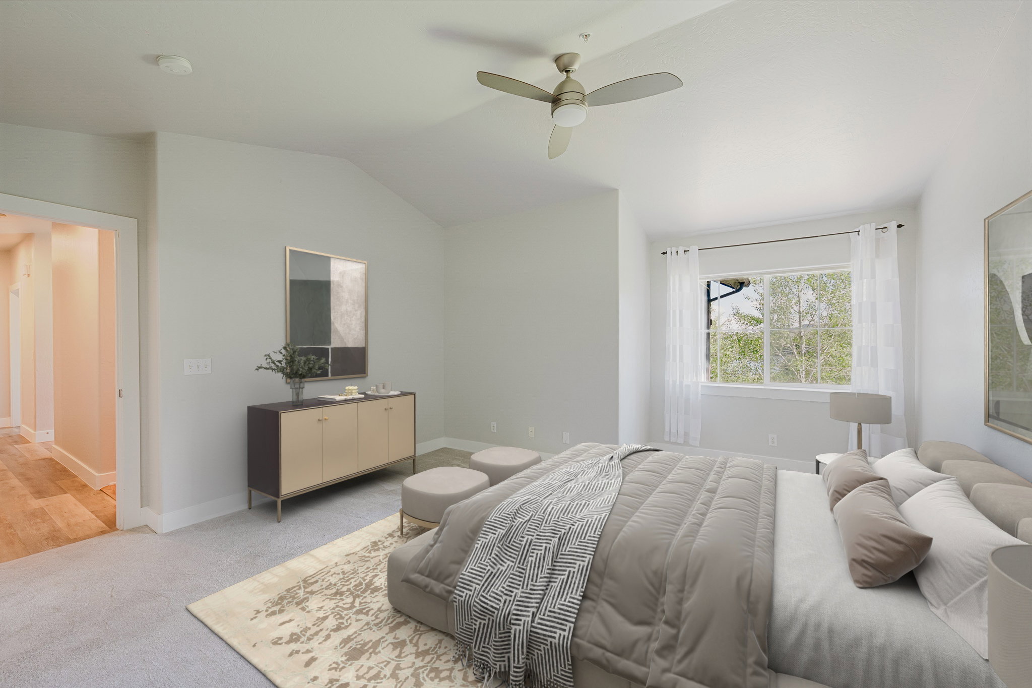 Bedroom featuring a vaulted ceiling, large window, ceiling fan with integrated lighting, and plush carpeting - Virtually staged