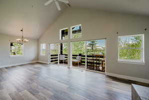 Vaulted ceilings with a ceiling fan, recessed lighting, and wood-finish flooring