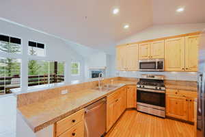 Kitchen with wood flooring, natural wood cabinetry, and granite countertops