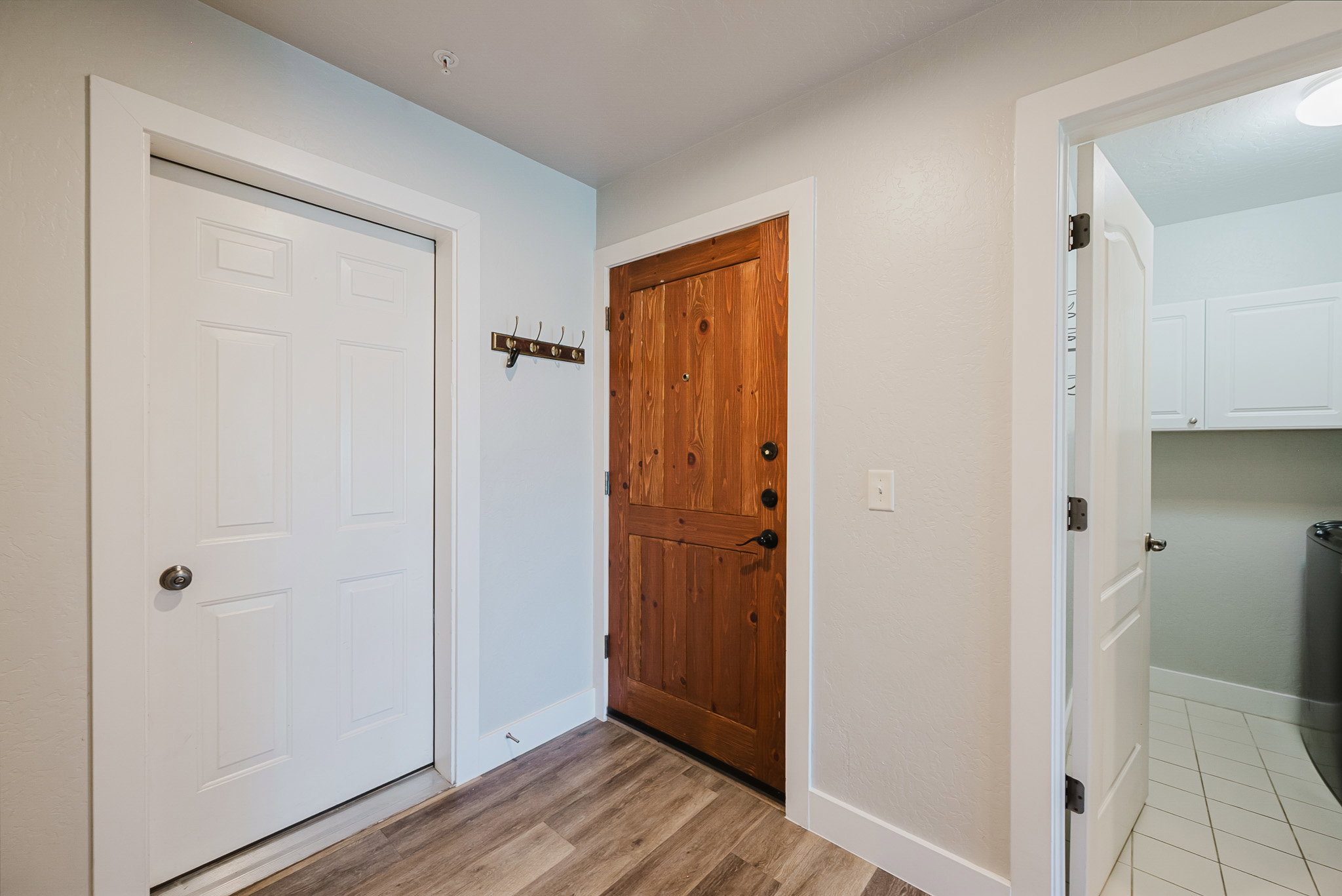 Unit has attached garage. White door is garage, brown door is entry door, opoen door is laundru room