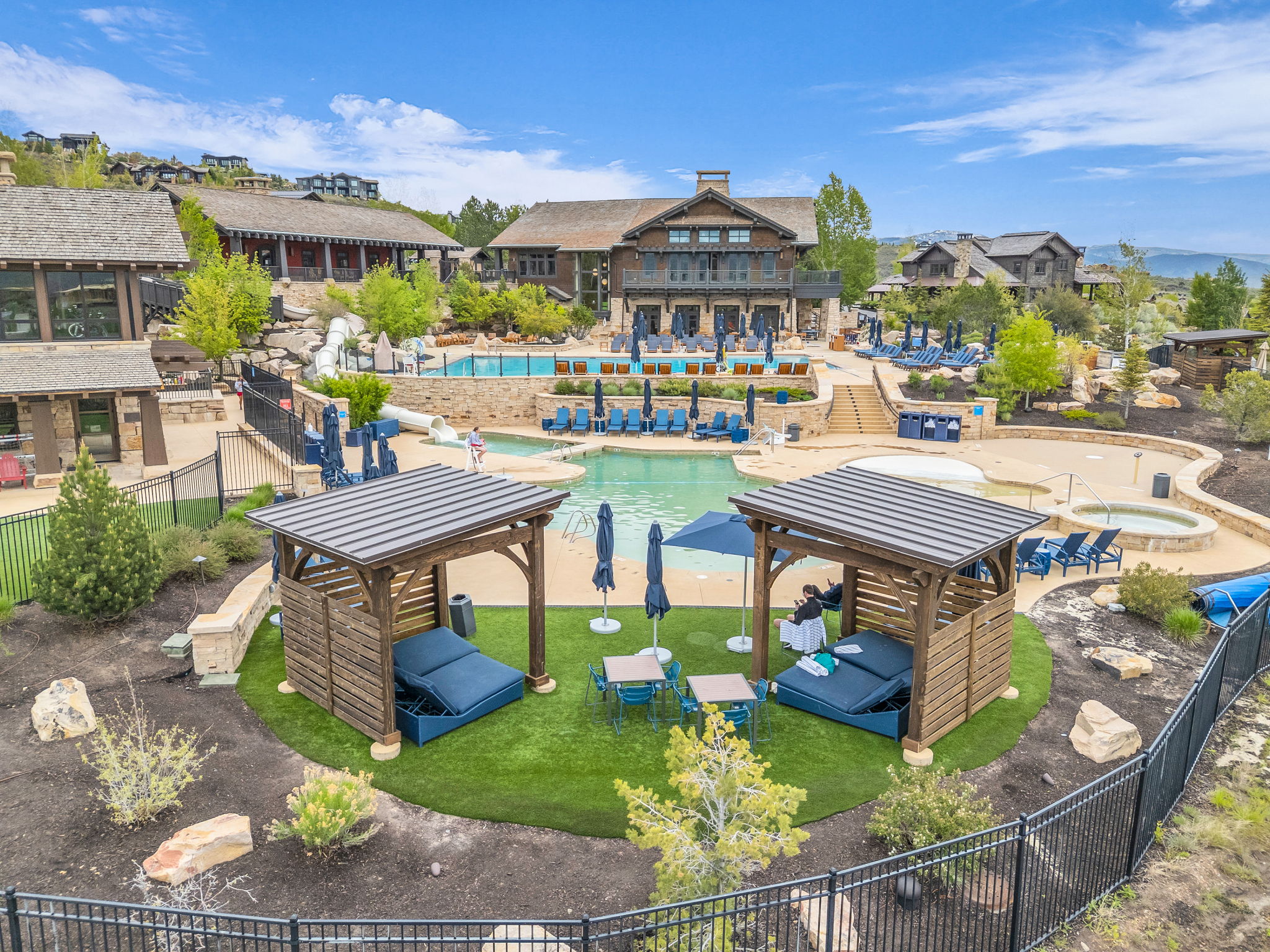 Resort-style pool area featuring multiple swimming pools, water slides, and lounge seating