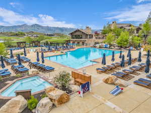 Expansive outdoor pool area featuring a large swimming pool, an integrated spa, and extensive surrounding patio space with lounge seating