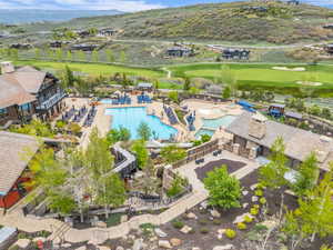 Expansive community pool area featuring a large rectangular pool, a winding leisure pool, and multiple water slides
