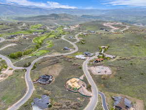 Sweeping aerial perspective showcasing a residential community amidst rolling hills and distant mountains