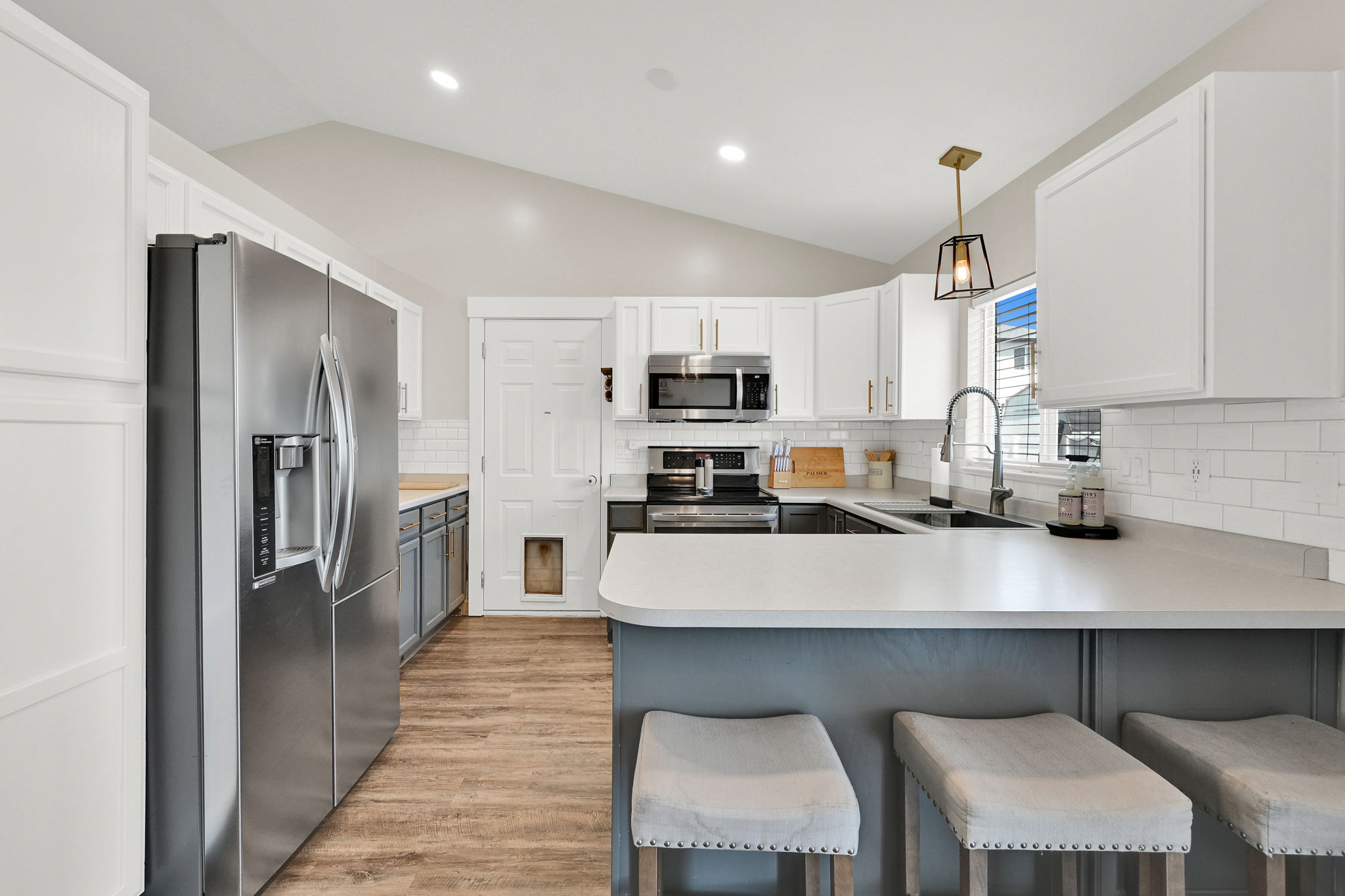 Modern kitchen featuring a vaulted ceiling and wood-finish flooring