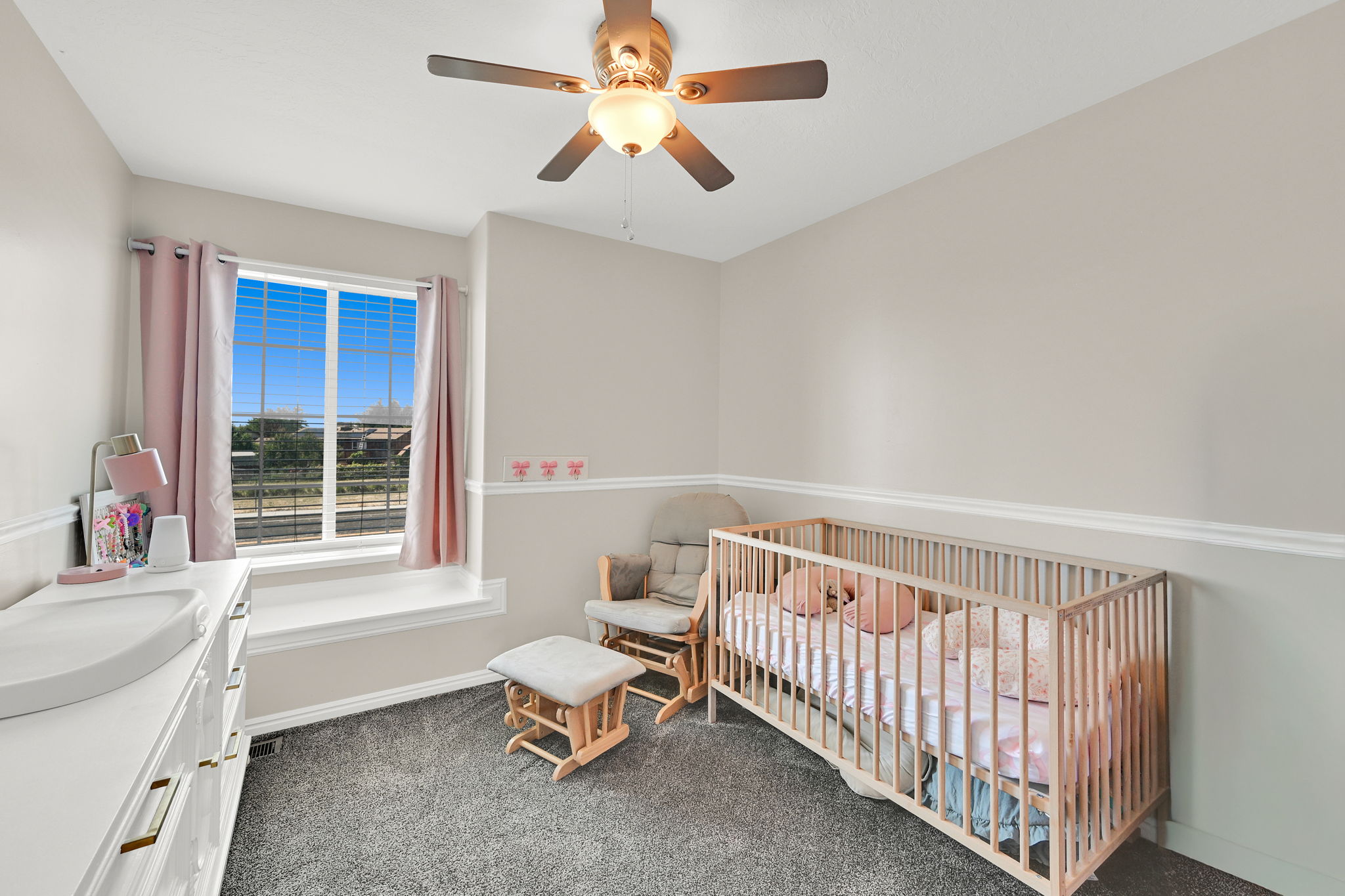 Neutral wall paint with chair rail molding and durable carpet flooring