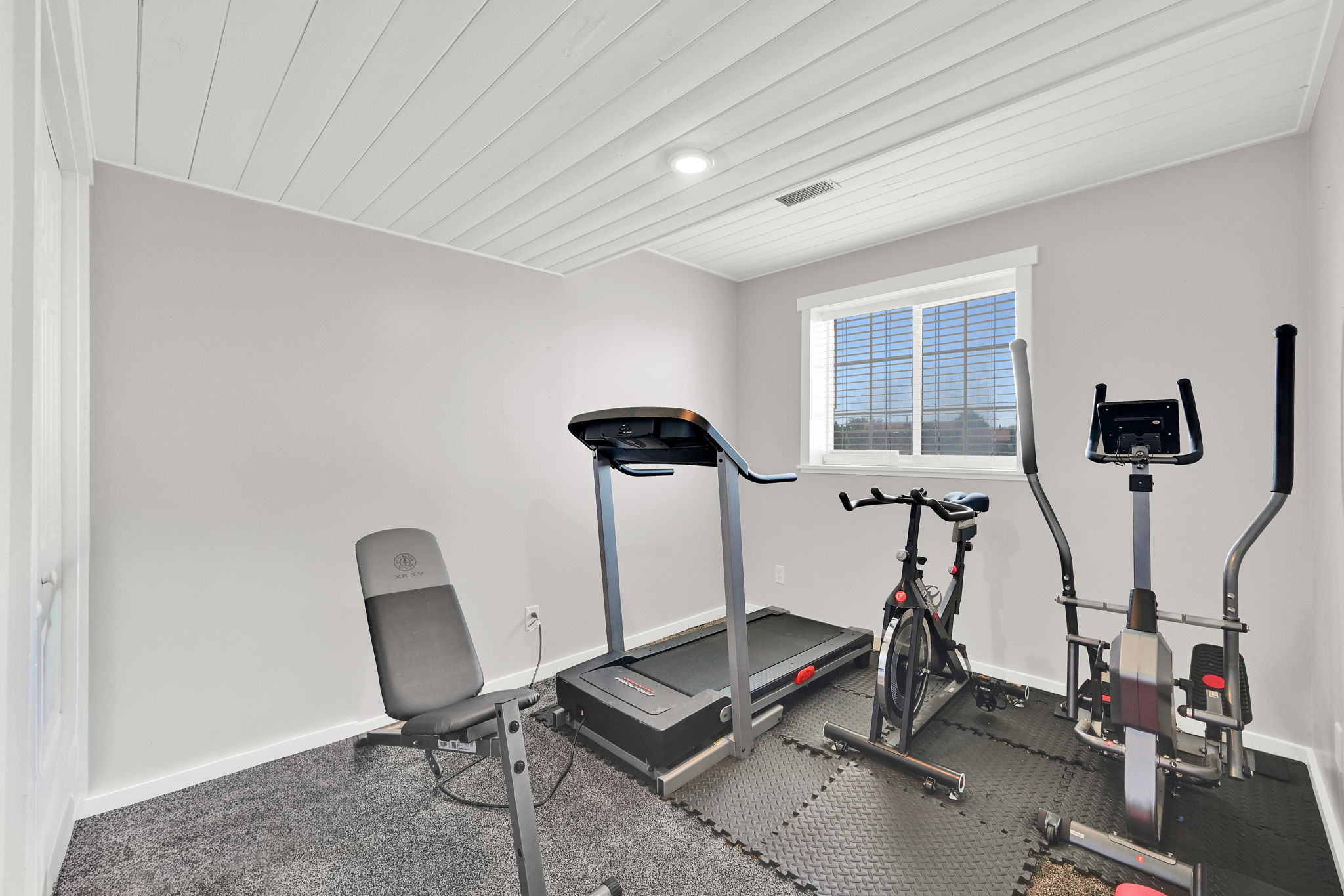 Interior room featuring a white planked ceiling, light gray wall paint, and gray carpet