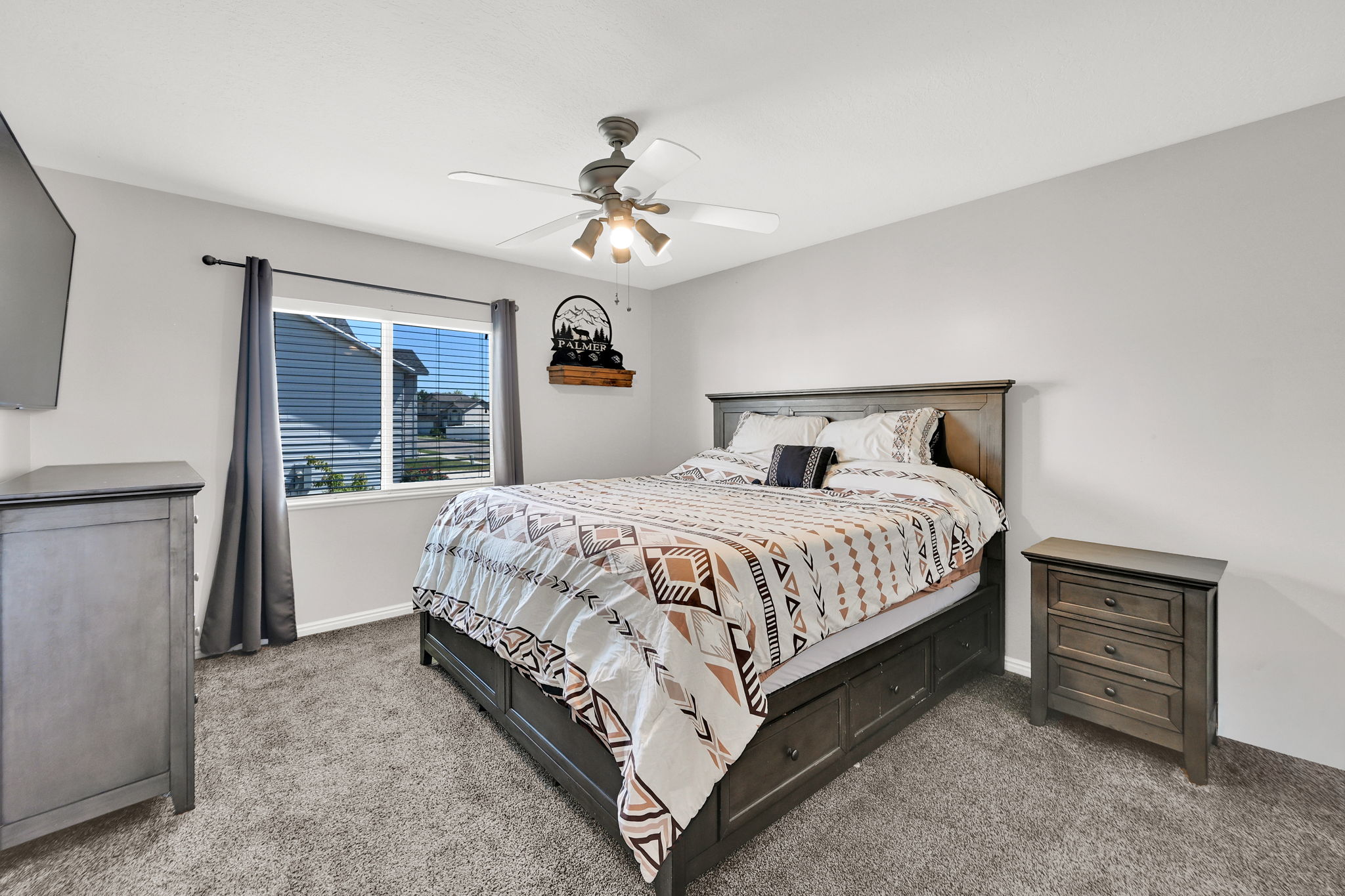 Carpeted room with a ceiling fan light fixture, white walls, and a window featuring horizontal blinds