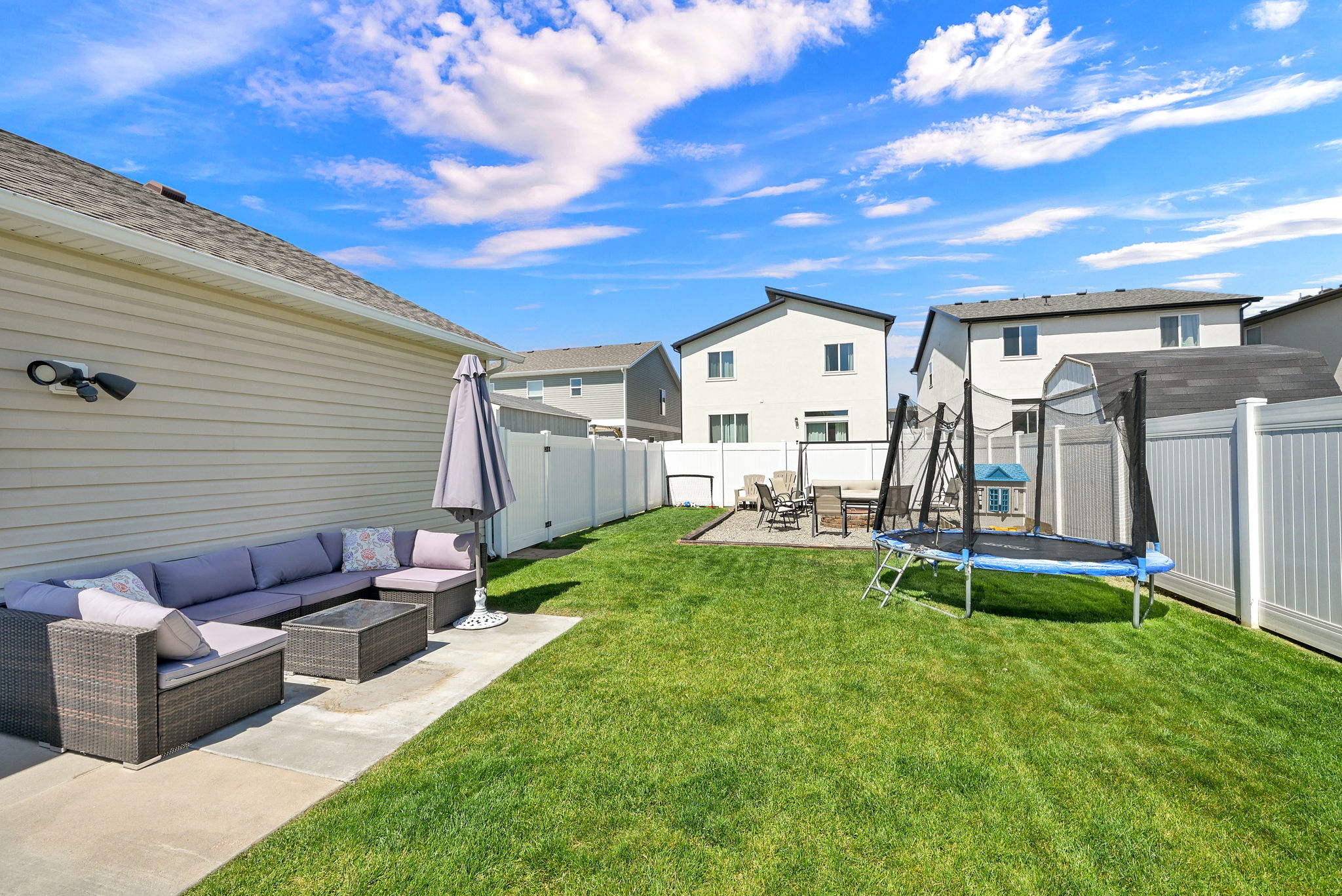Expansive backyard featuring a manicured lawn, a concrete patio, and a privacy fence