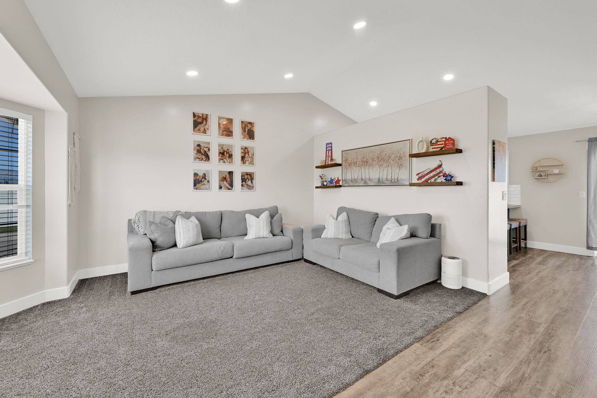 Spacious living area featuring neutral-toned walls, recessed lighting, and a vaulted ceiling