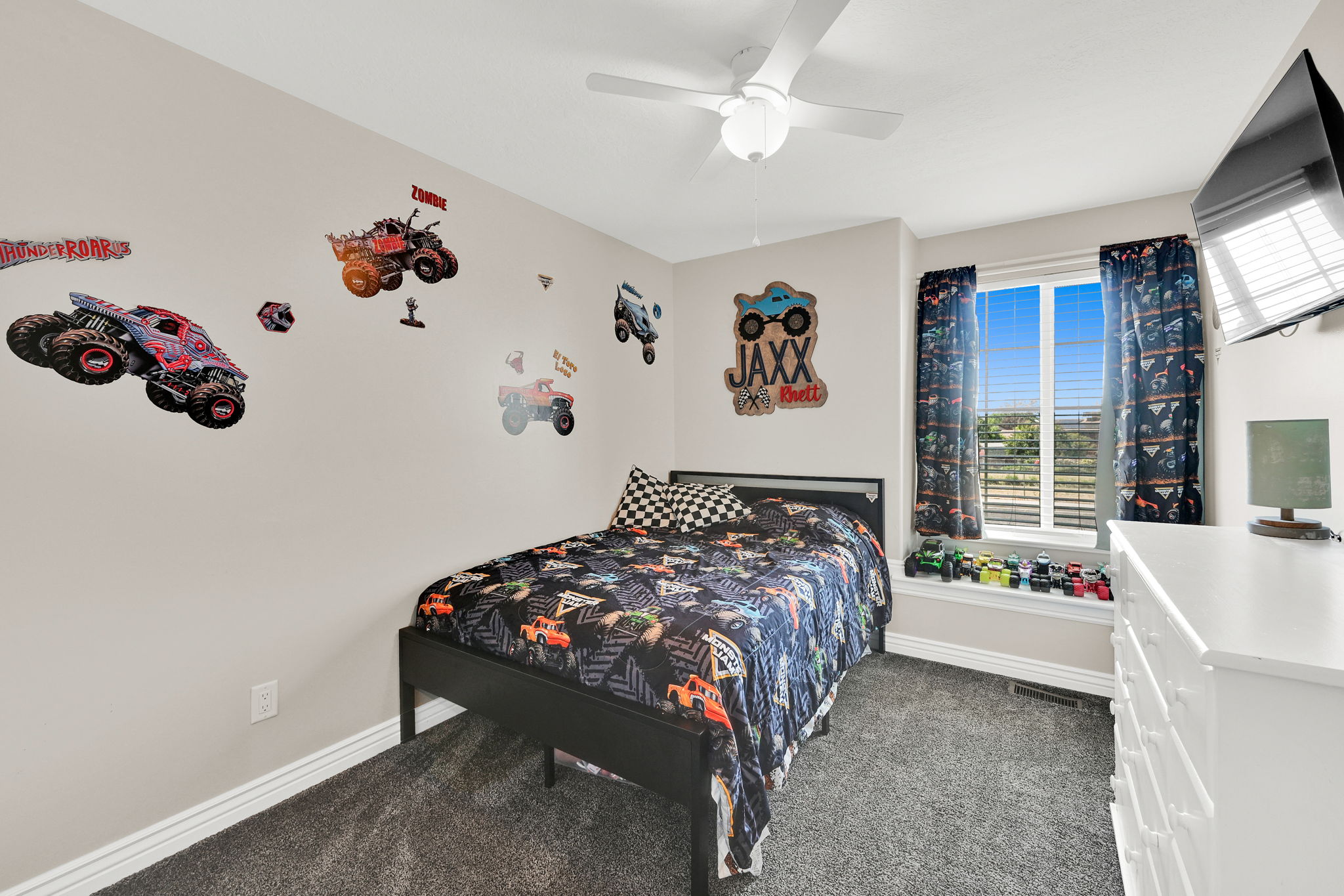 Bedroom featuring neutral-toned walls, dark gray carpet flooring, and a ceiling fan with integrated lighting