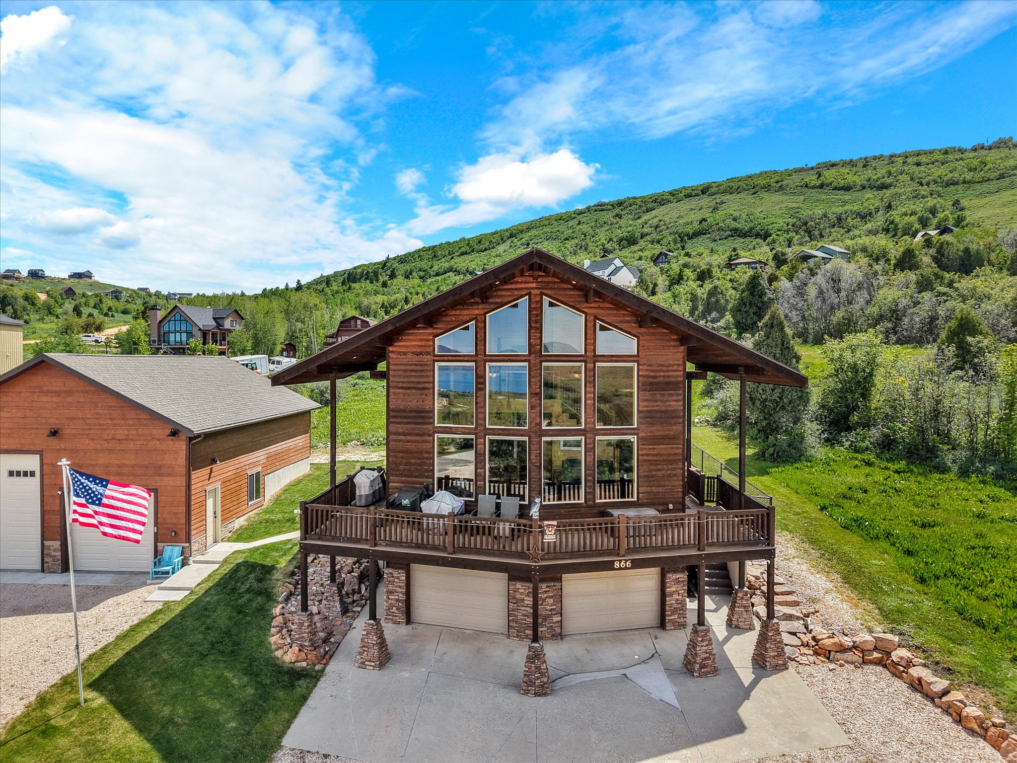 Mountain-style home with a prominent gabled roofline and extensive exterior decking