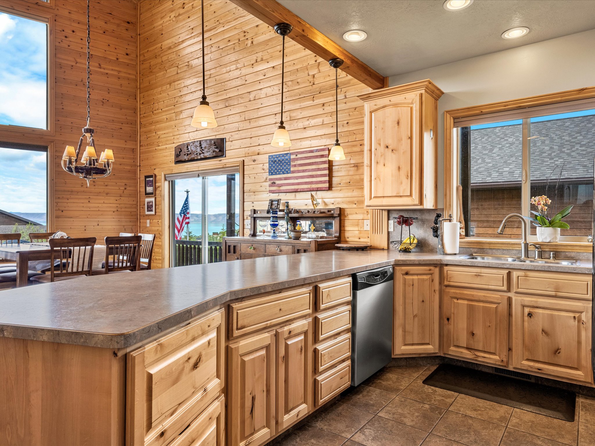 Kitchen featuring light wood cabinetry, stainless steel dishwasher, and a double basin sink