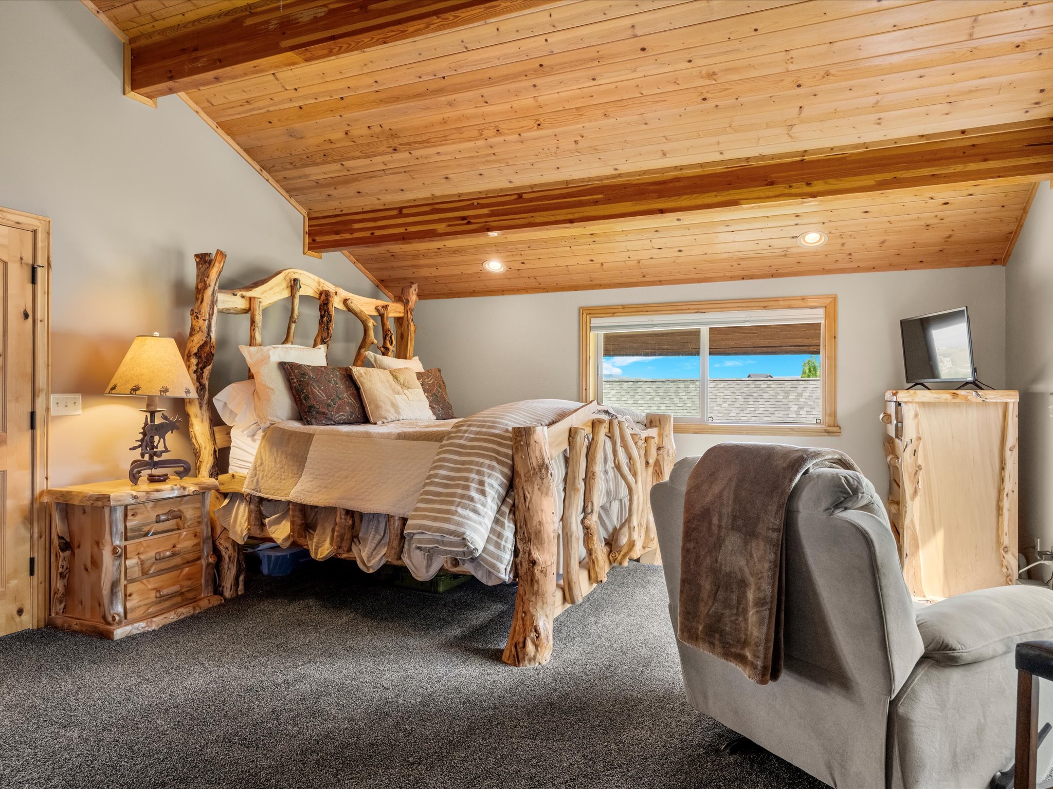 ensuite featuring vaulted wood-paneled ceiling with exposed beams