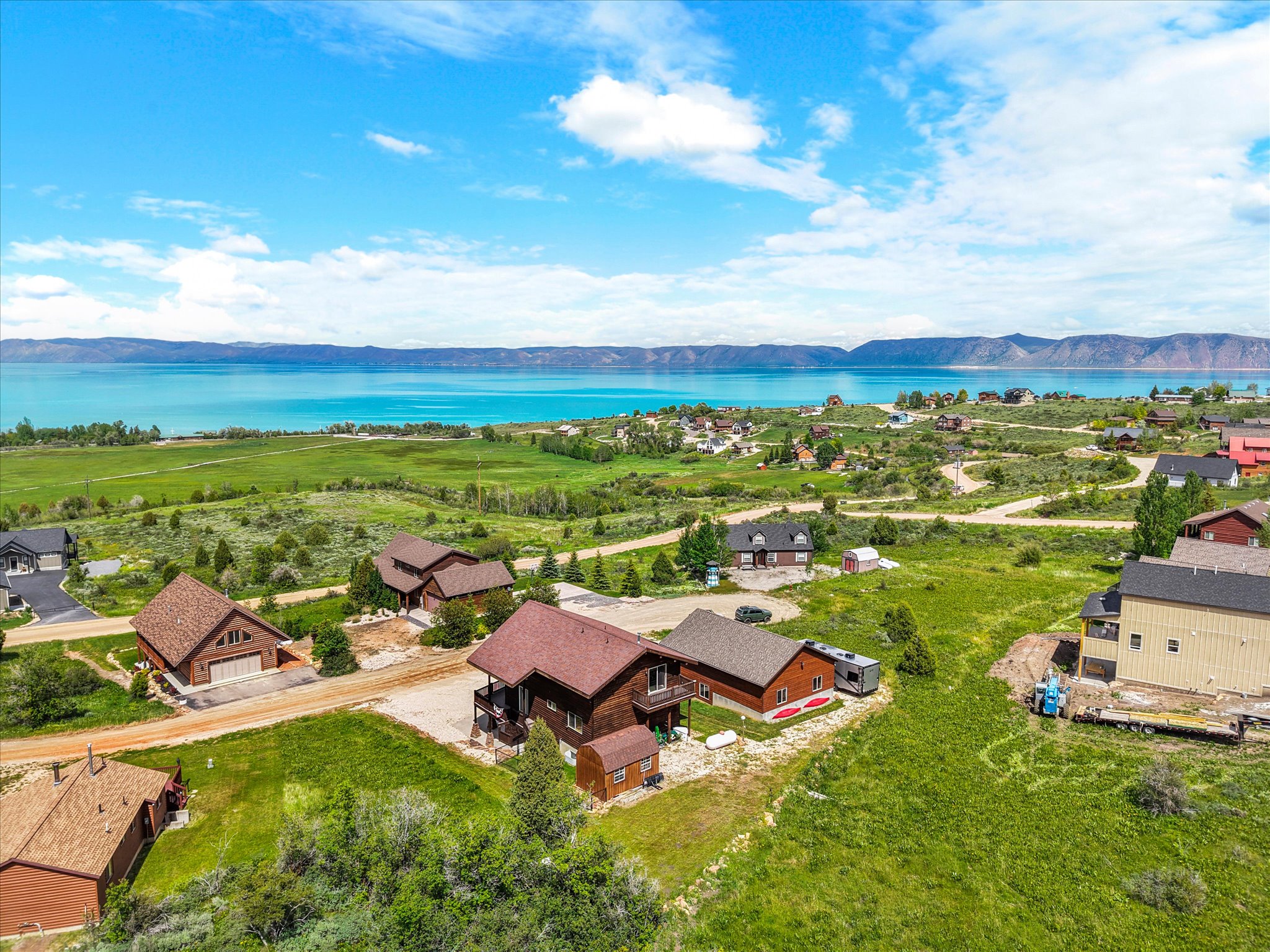 Expansive lakefront community featuring a prominent body of water, distant mountain ranges.