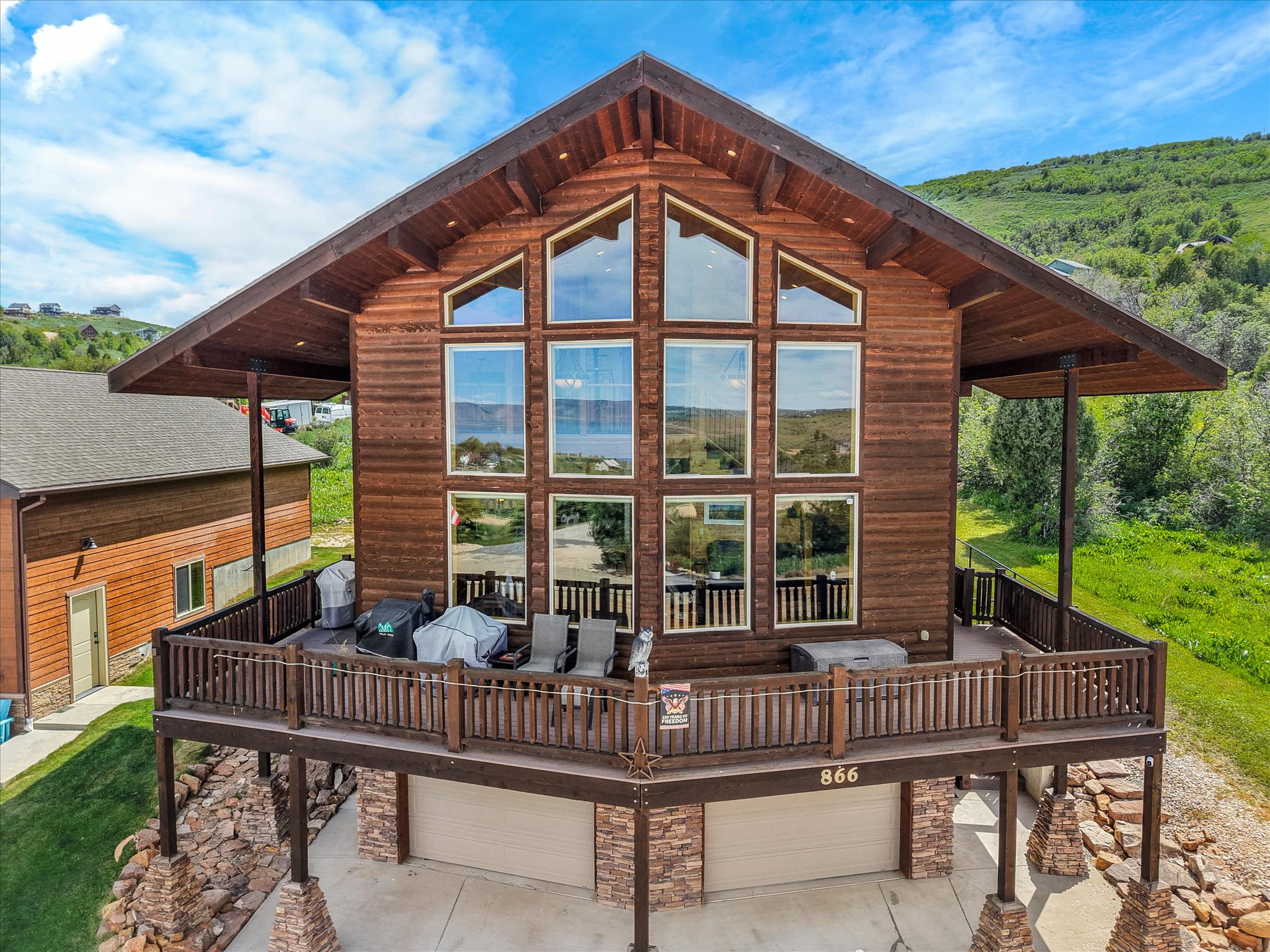 Timber-frame exterior featuring picture window wall and a substantial deck