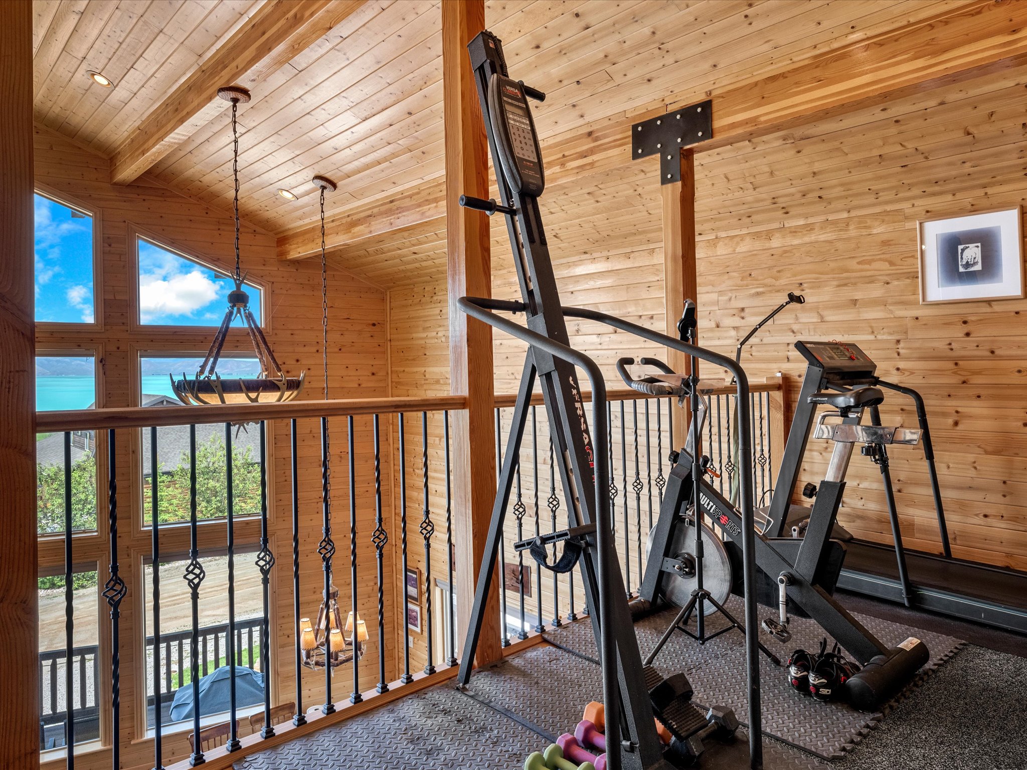Loft space featuring extensive wood paneling and exposed wood beams