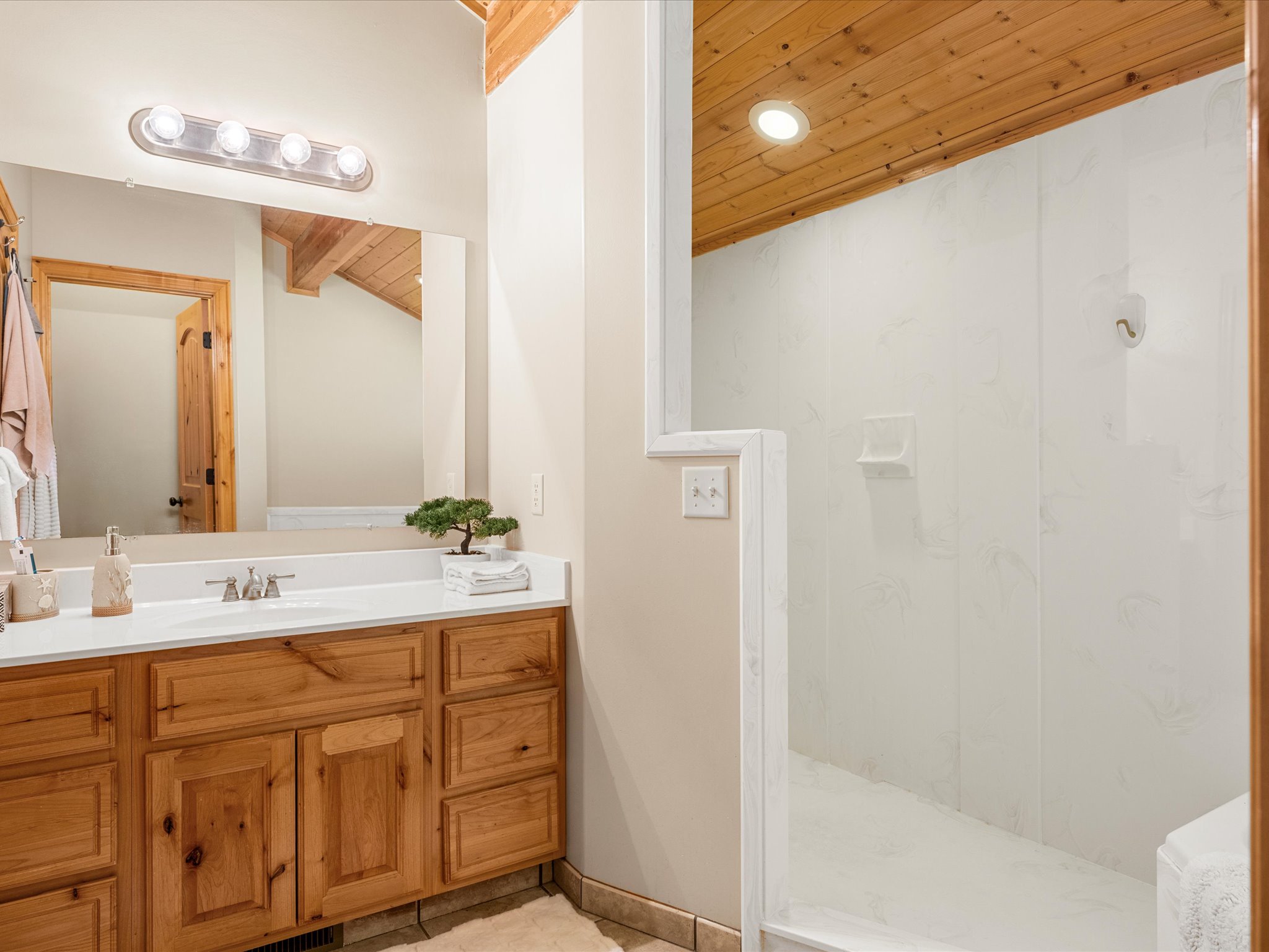 Bathroom featuring a light wood-finish vanity with an integrated sink and reflective mirror