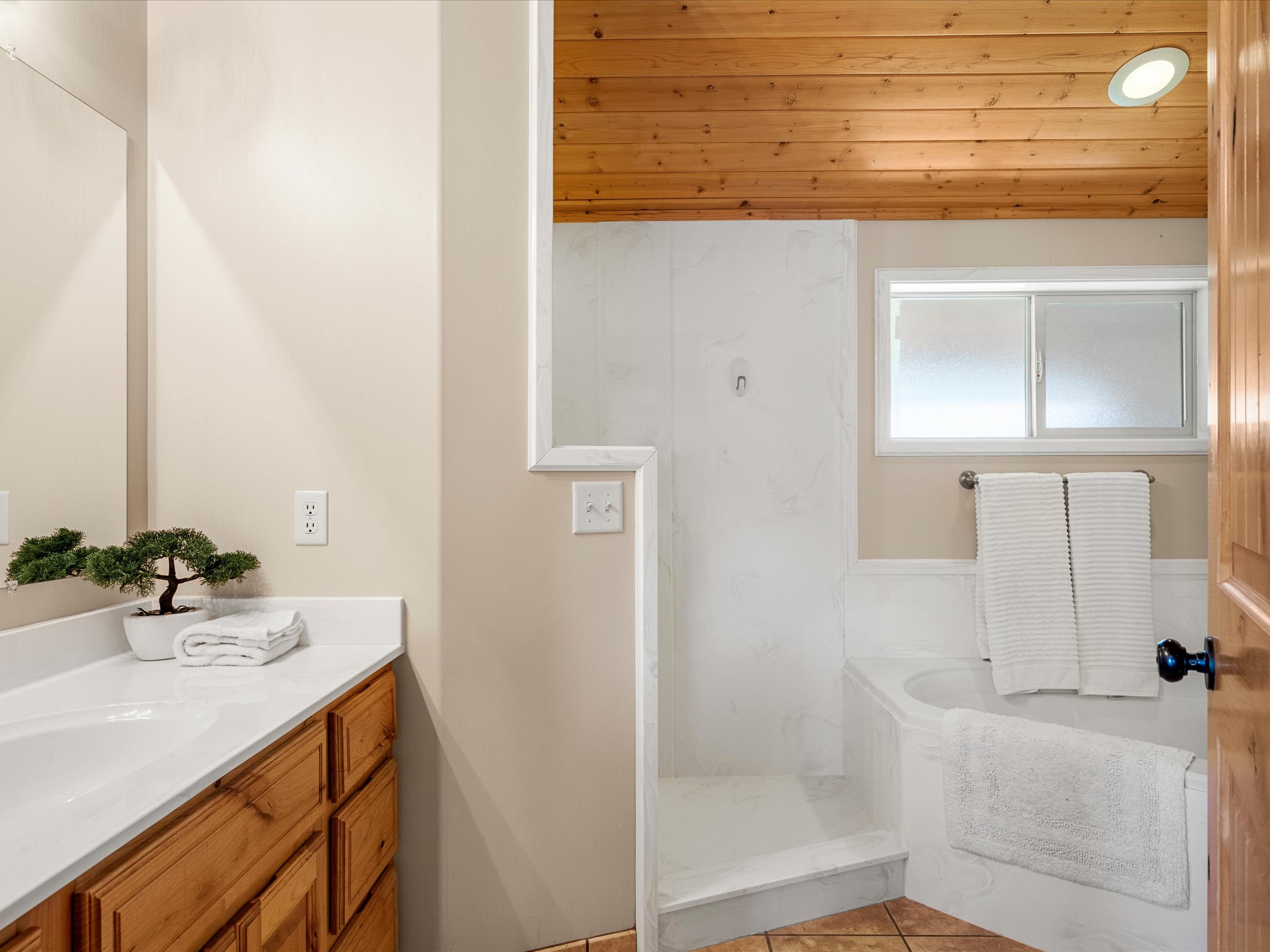 Bathroom featuring a wood-finish plank ceiling, a built-in shower, and a soaking tub