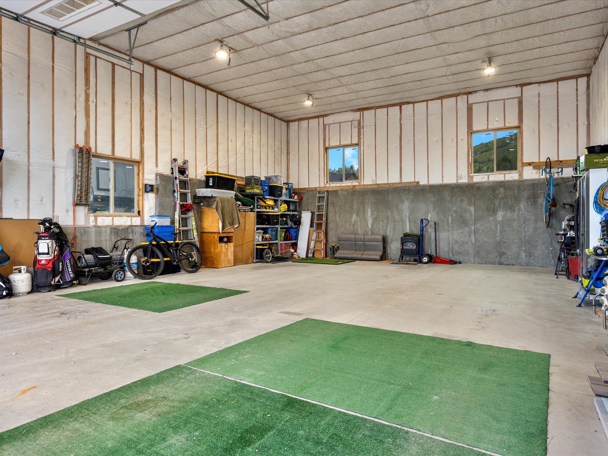 Detached garage featuring a high ceiling, concrete flooring
