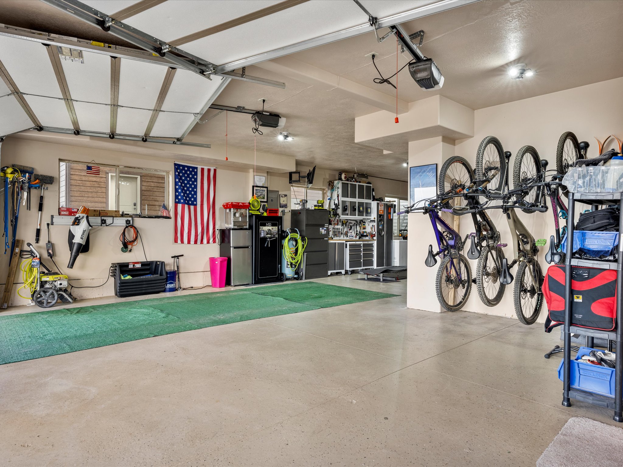 Spacious garage featuring a concrete floor, overhead lighting, and an automatic garage door opener