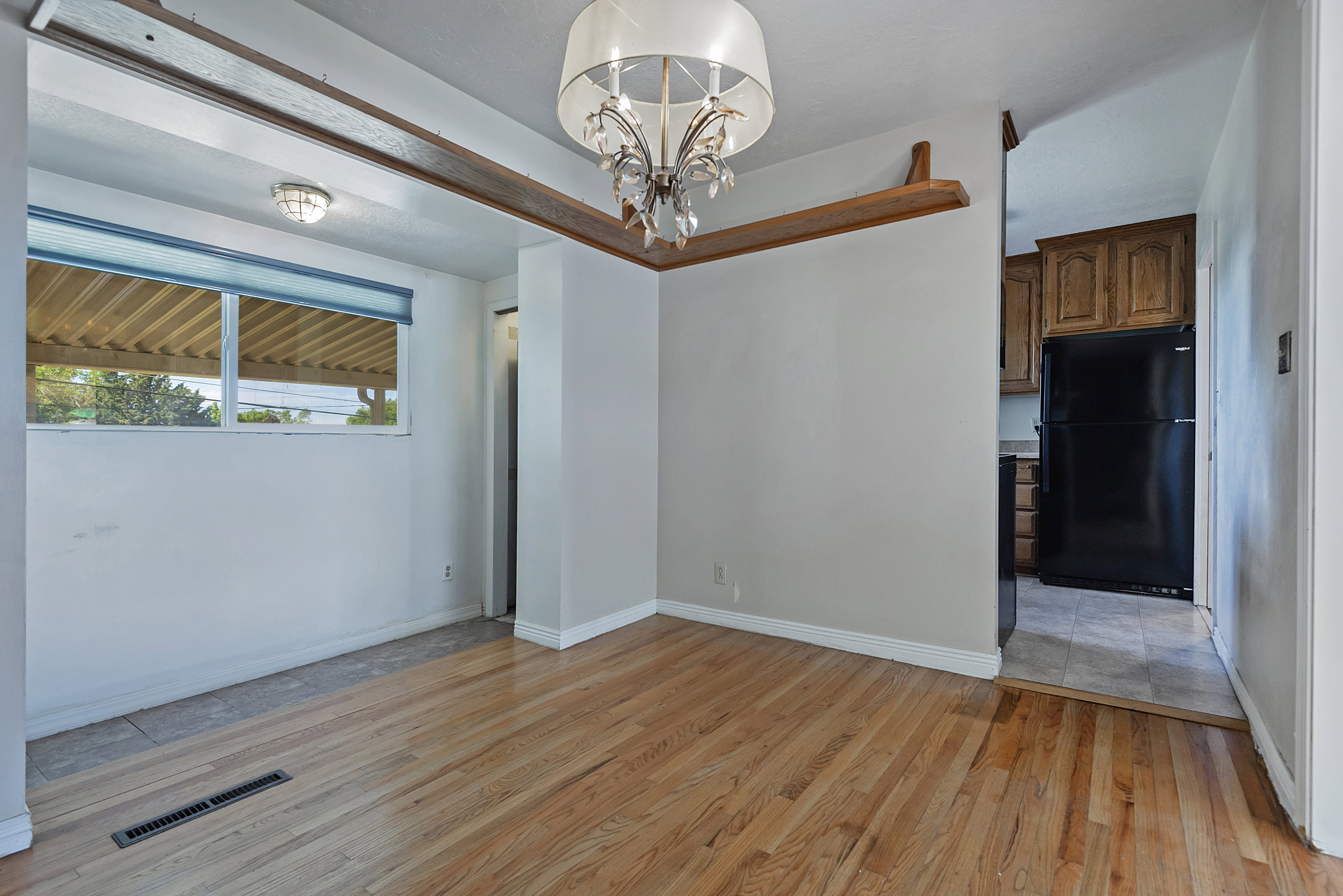 Hardwood flooring extends through the main area, complemented by a decorative chandelier