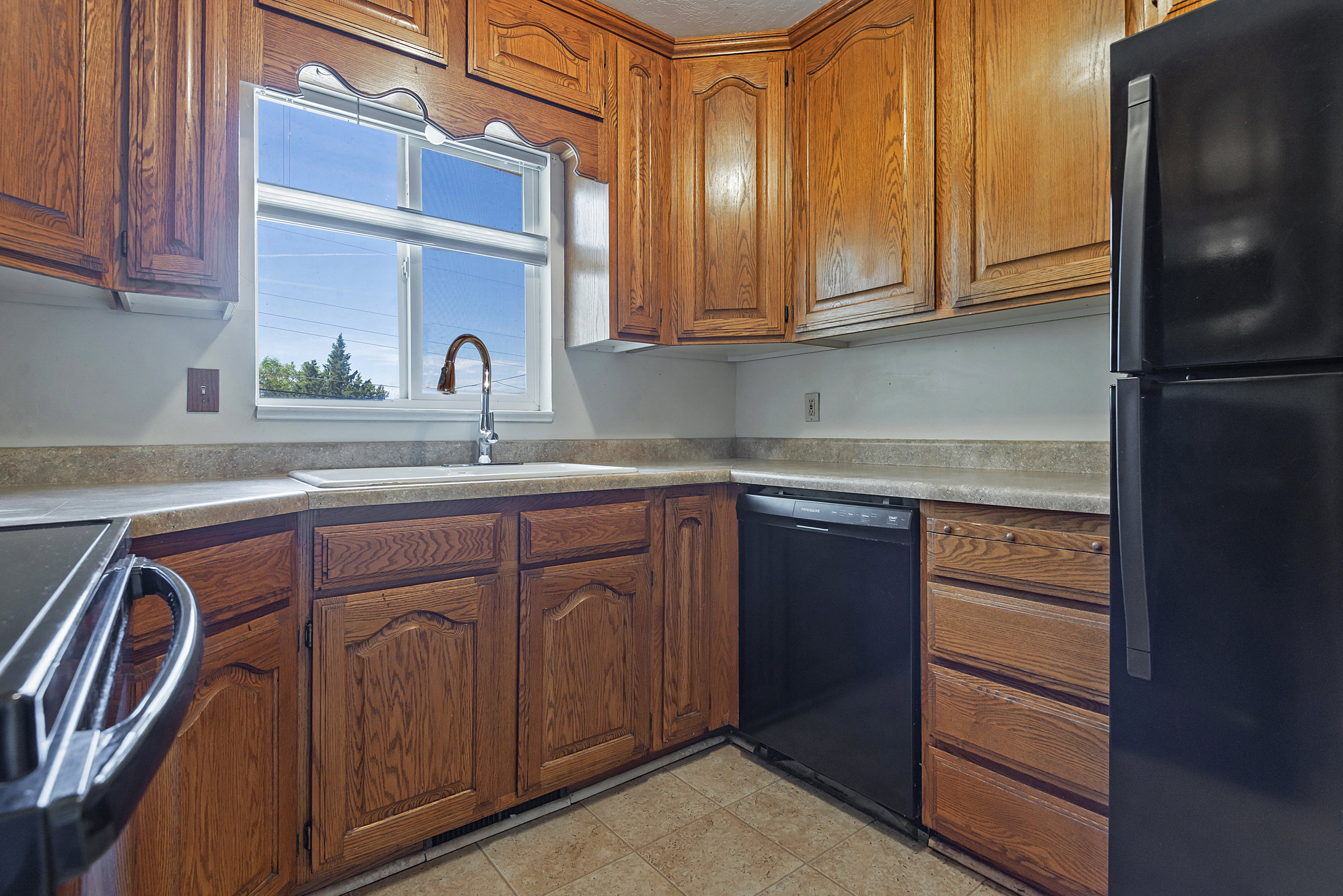 Kitchen featuring wood-finish cabinetry and a window above the sink