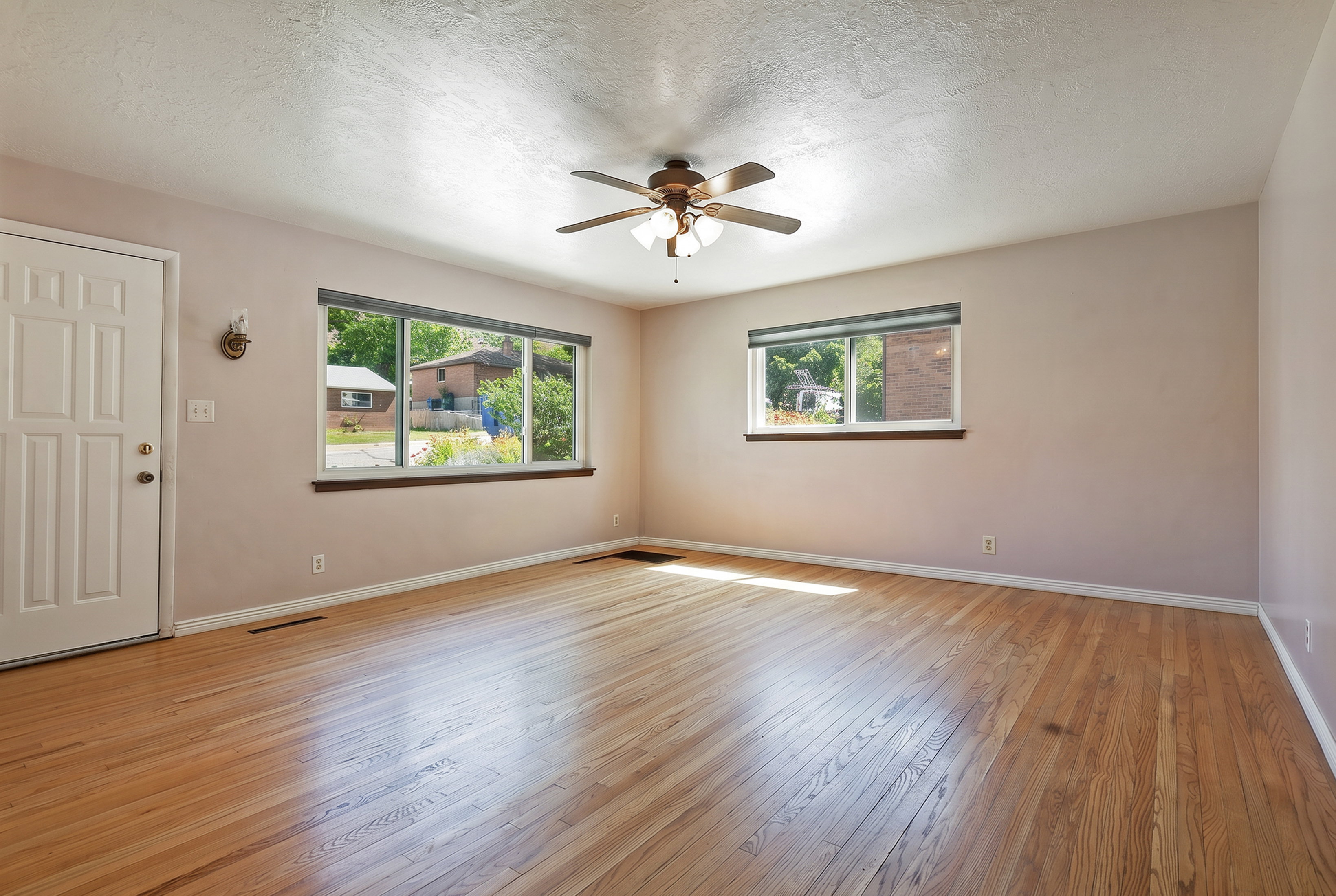 Hardwood flooring throughout a room with multiple windows