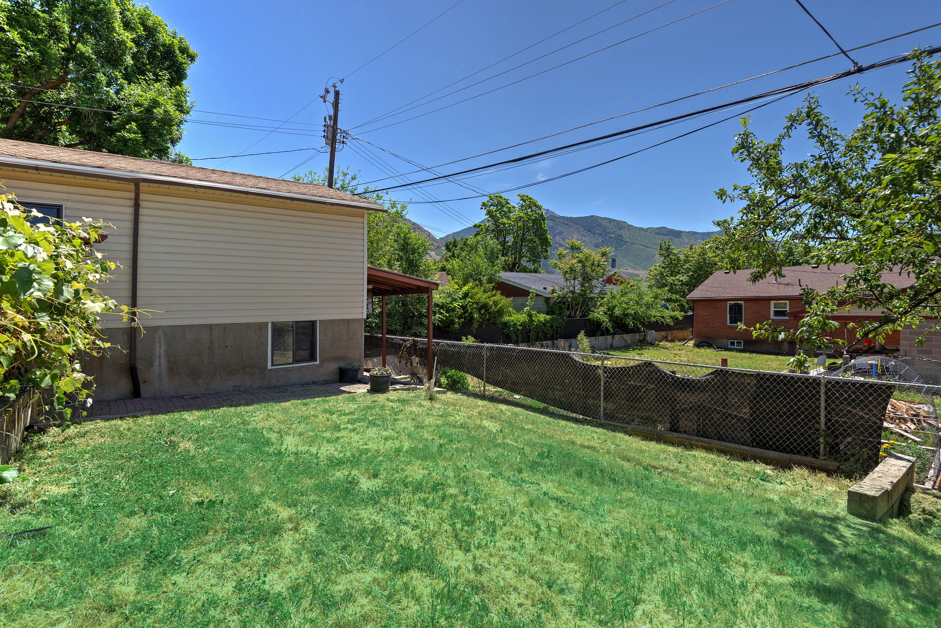 Spacious backyard with a chain-link fence and mountain backdrop