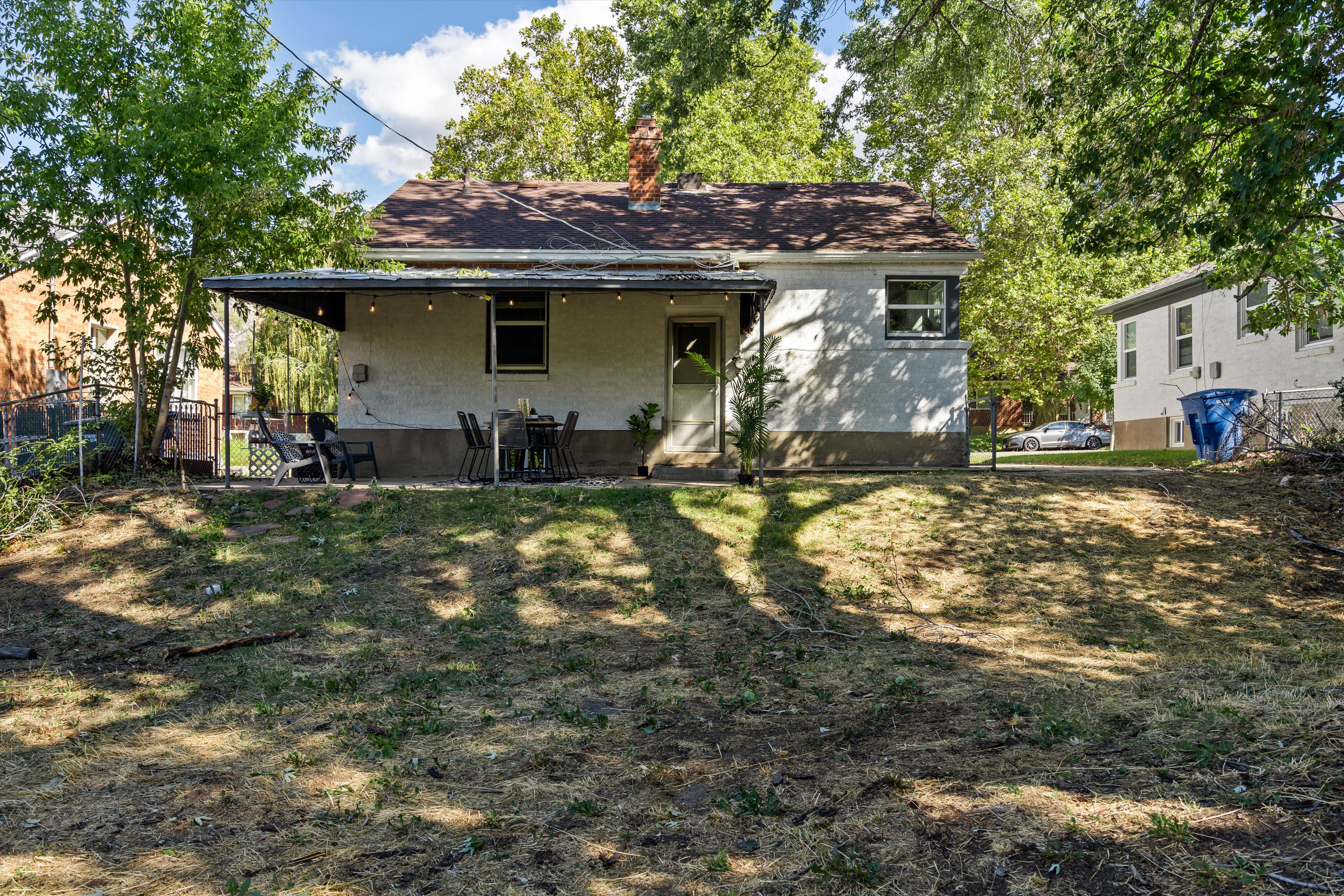 Rear exterior featuring a covered patio, stucco siding, and a fenced perimeter
