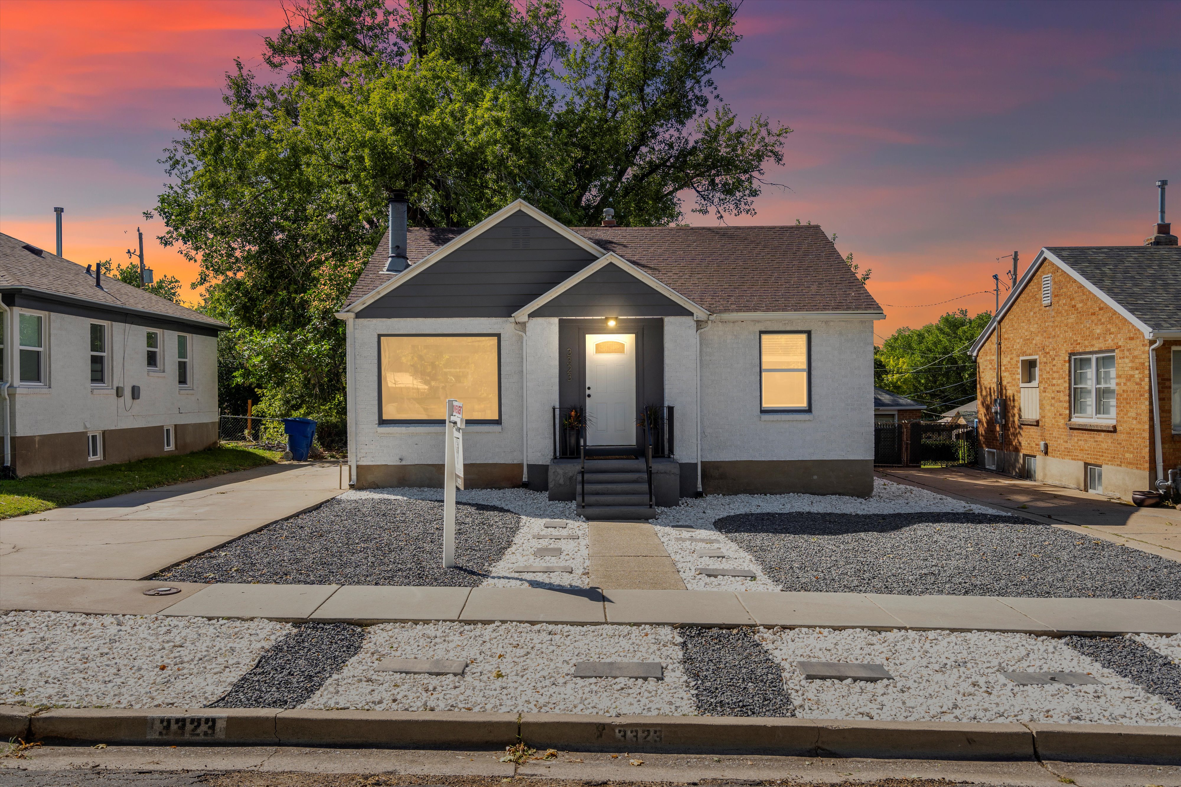 Single-story residence featuring a gray and white exterior with dark roof shingles