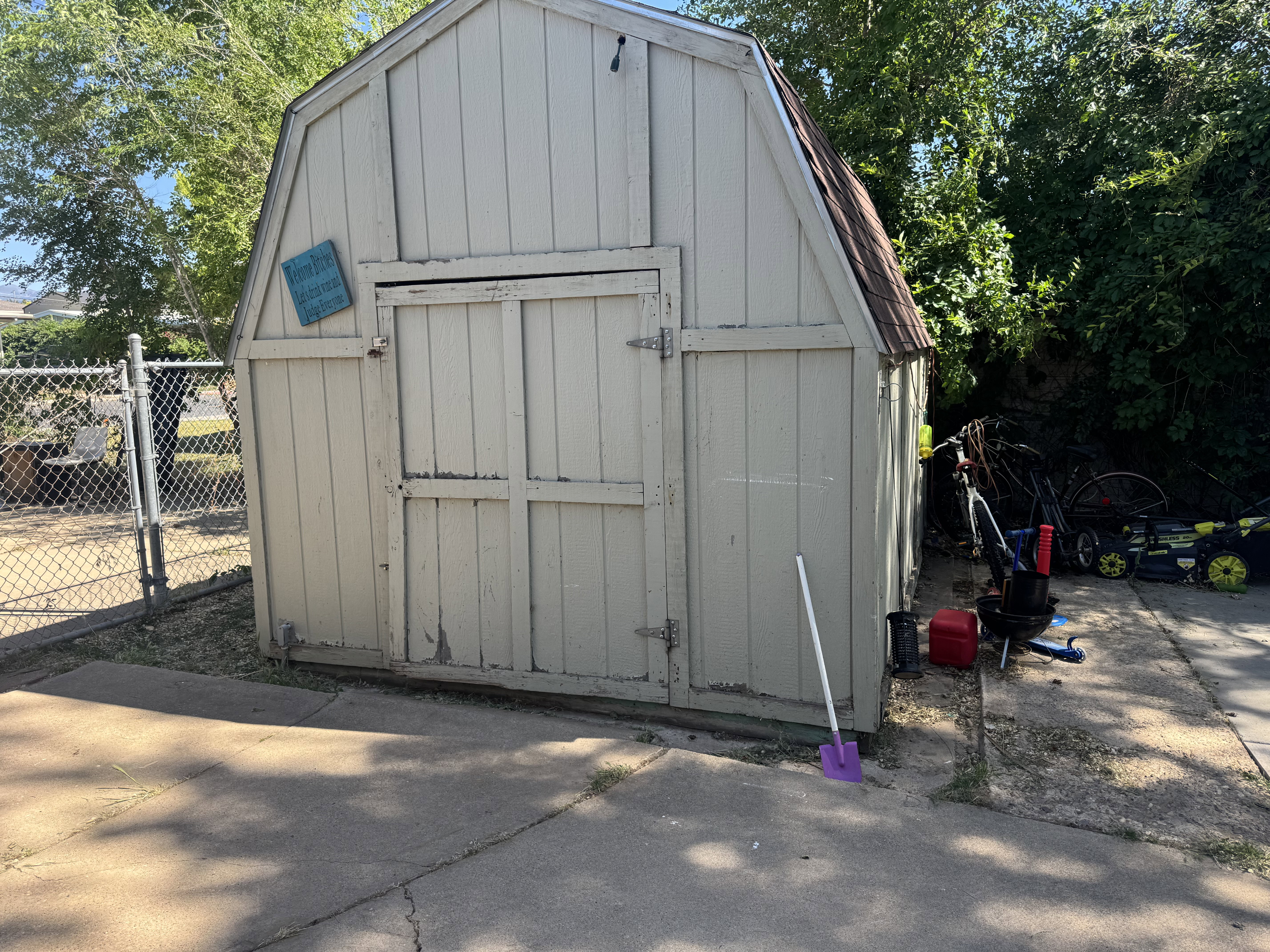 Wood-sided storage shed with a gambrel roof and double barn doors