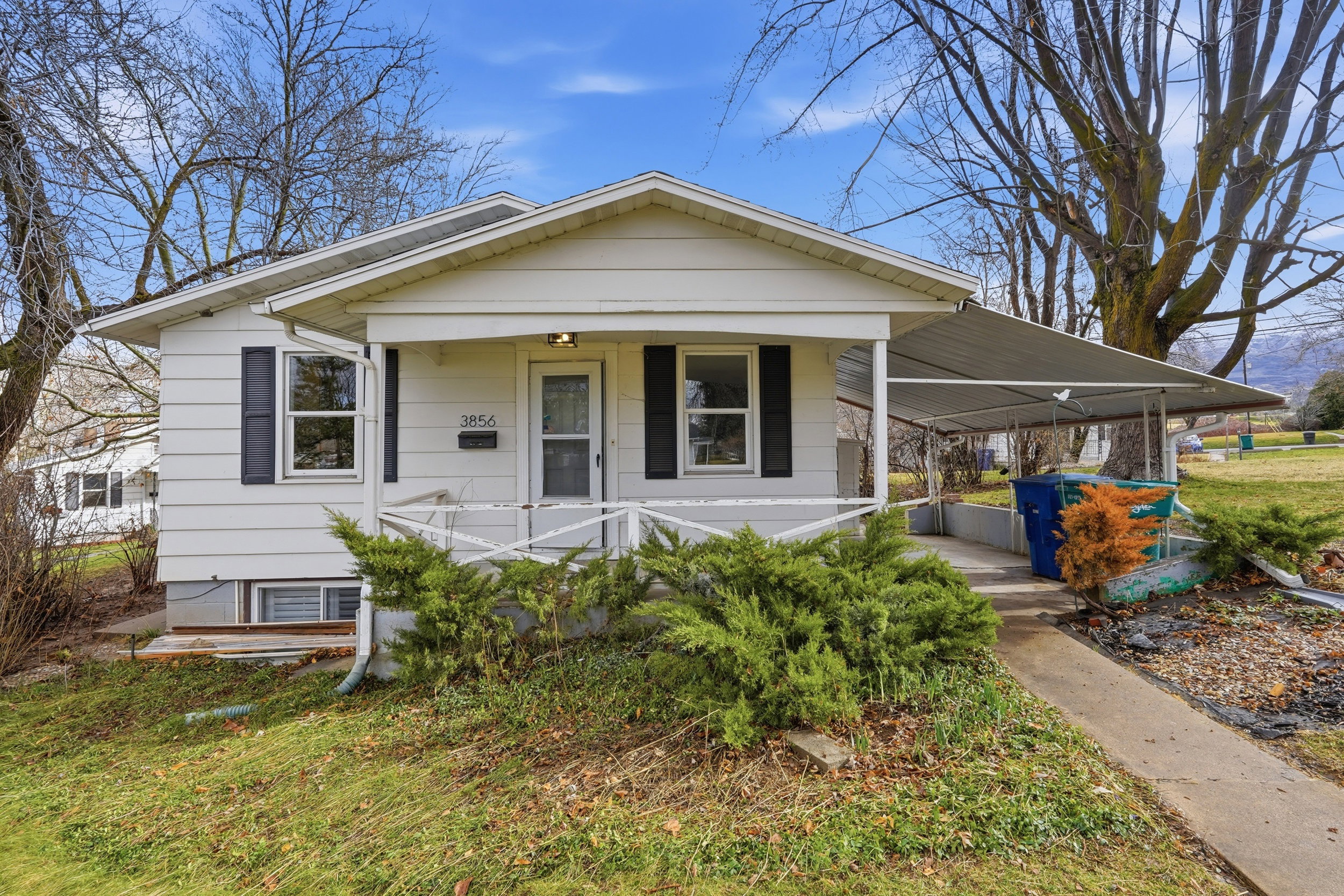 White siding exterior with black window shutters and a covered front porch