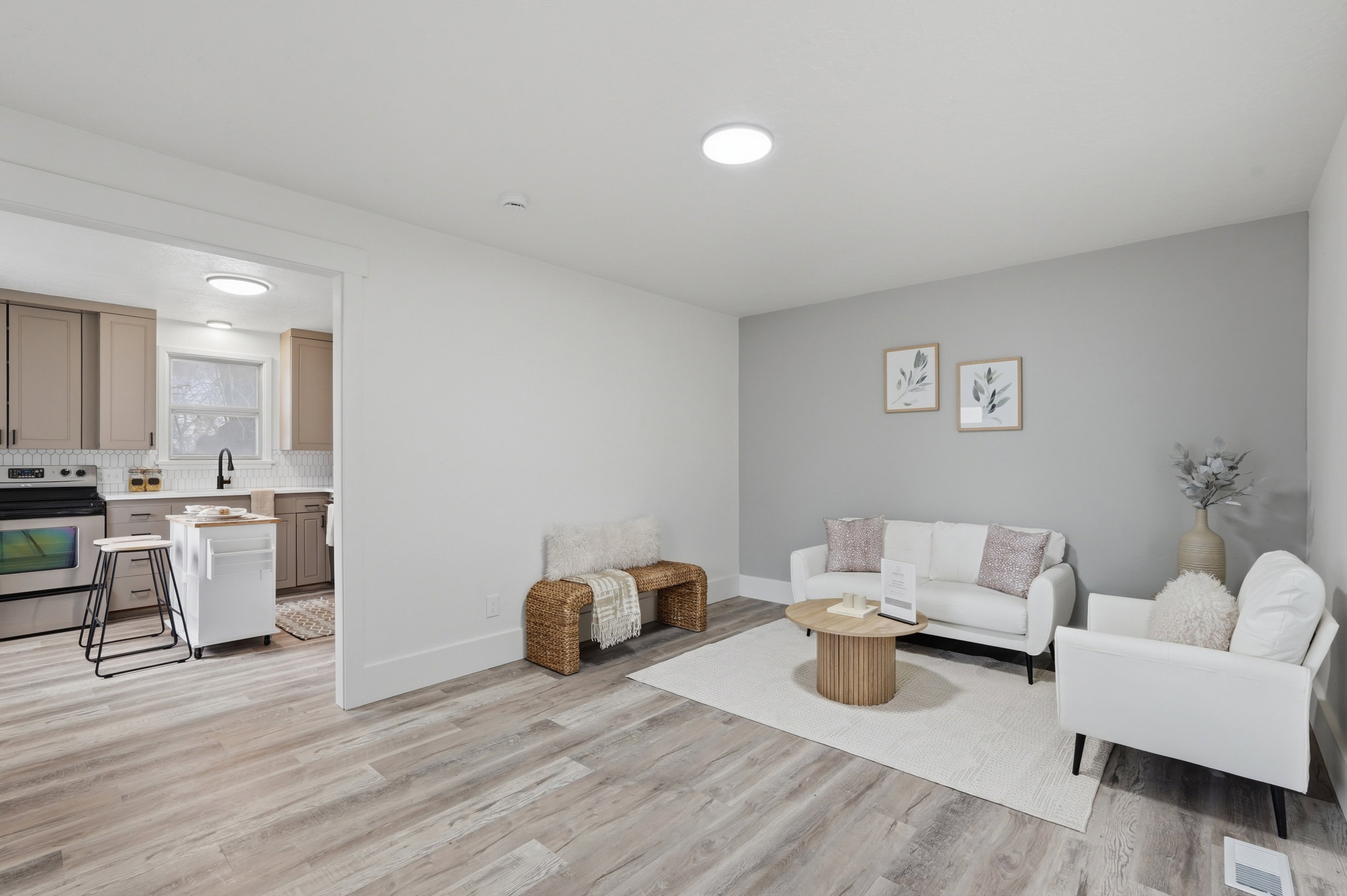 Open-concept living space featuring wood-finish flooring, recessed lighting, and a modern kitchen with stainless steel appliances, neutral cabinetry, and subway tile backsplash