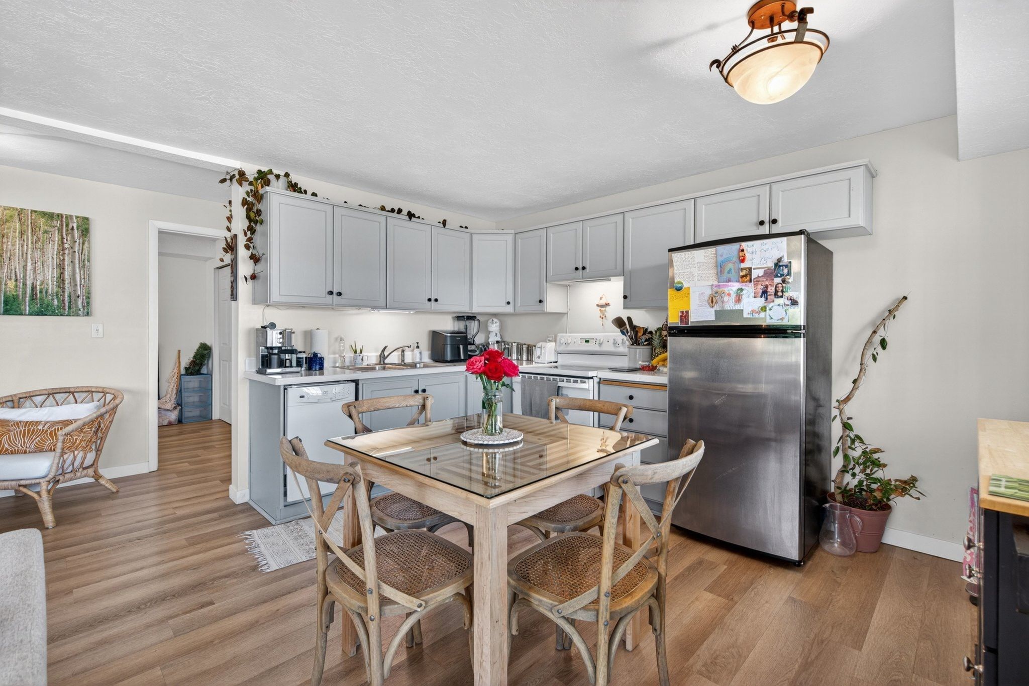 Kitchen featuring light wood-finish flooring, light gray cabinetry, and white countertops