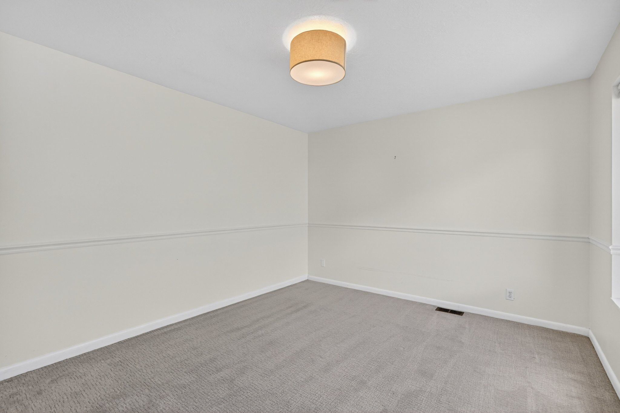 Neutral-toned walls with a white chair rail molding create a clean aesthetic